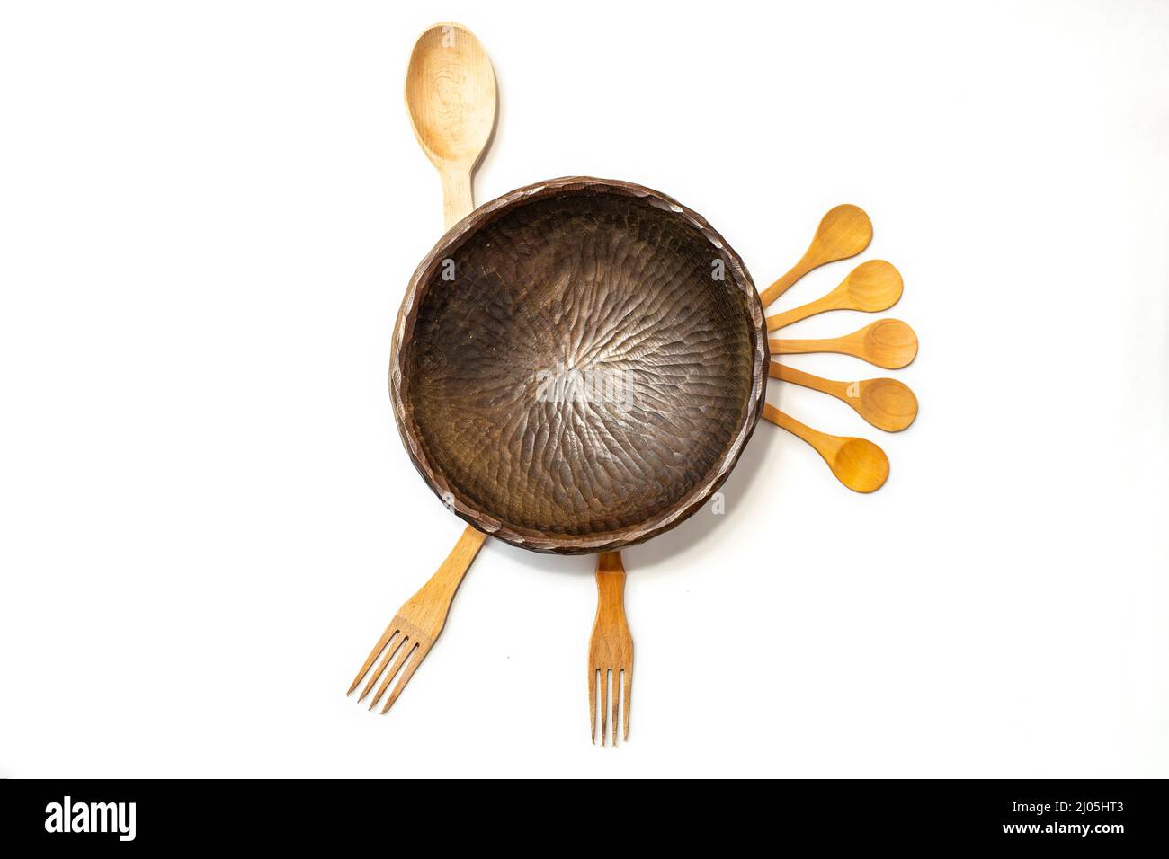 Bol en bois sculpté, cuillères à thé et fourchettes disposés comme une dinde, isolée sur fond blanc Banque D'Images