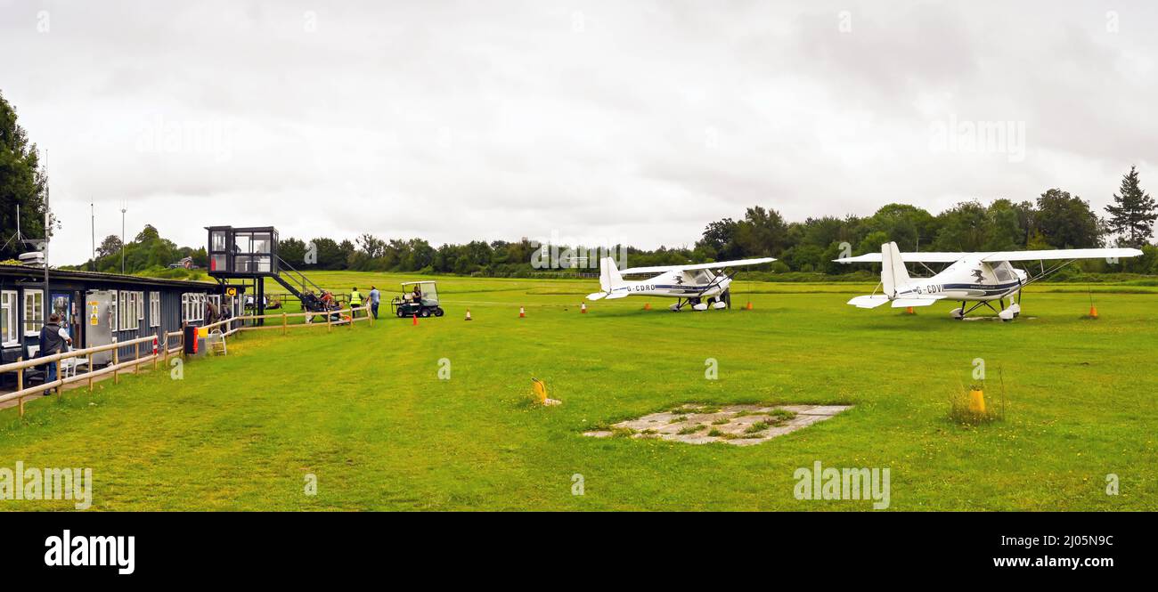 Popham, près de Basingstoke, Angleterre - août 2021 : petits avions légers garés devant les bâtiments et la tour de contrôle de l'aérodrome de Popham. Banque D'Images