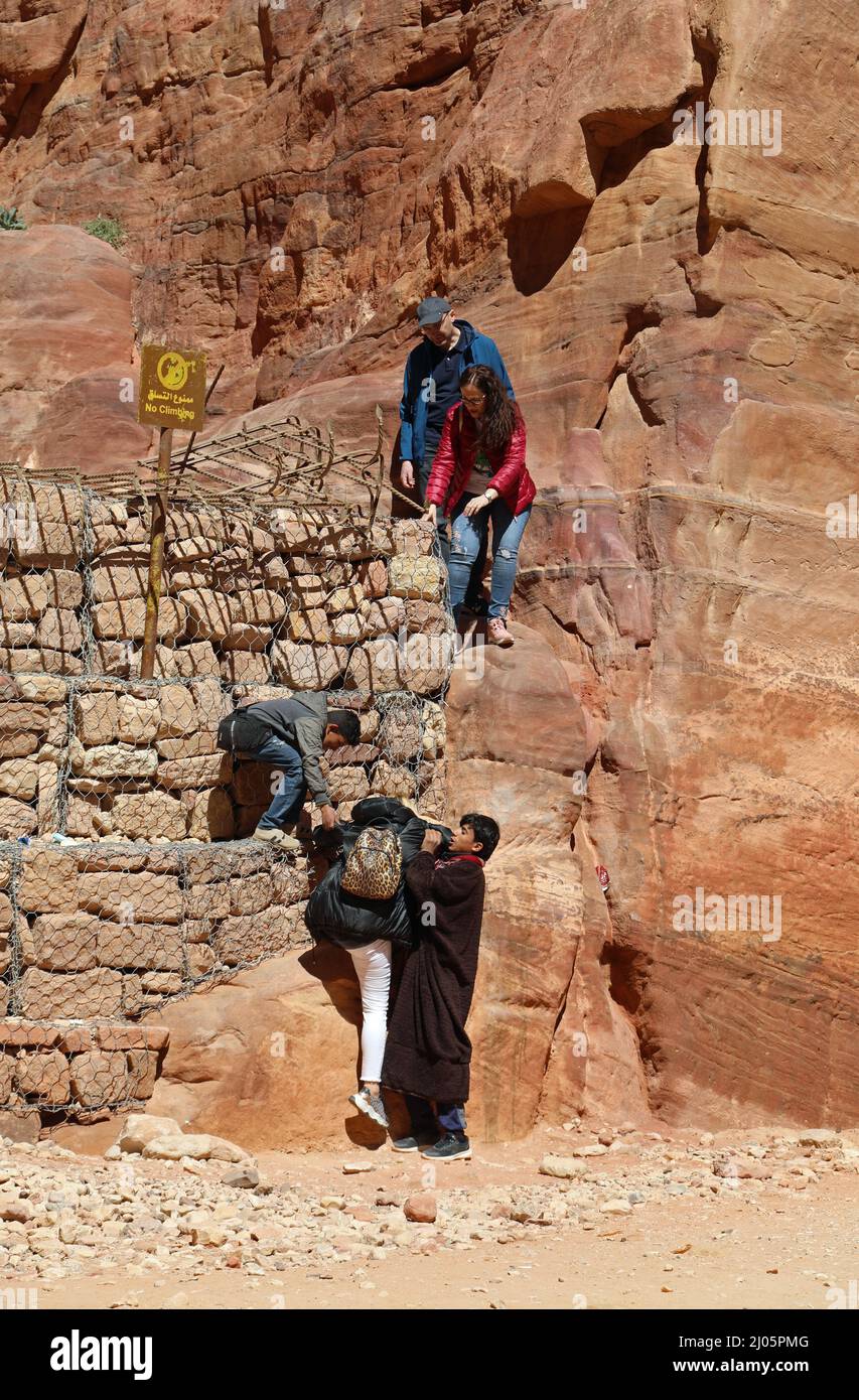 Touristes sur les rochers à Petra à côté d'un panneau pas d'escalade Banque D'Images