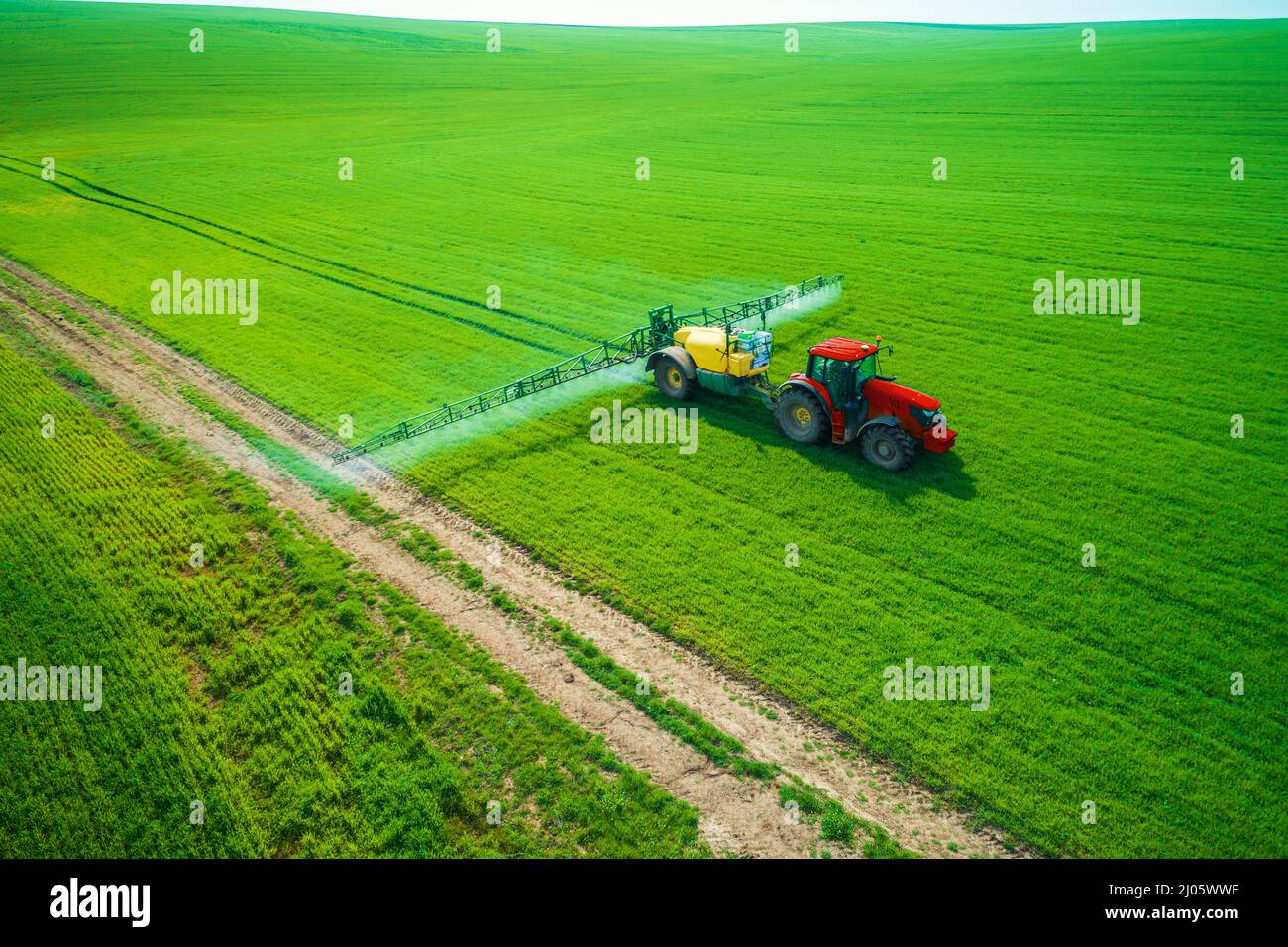 Vue aérienne de l'agriculture tracteur labourer et pulvériser sur terrain. Banque D'Images