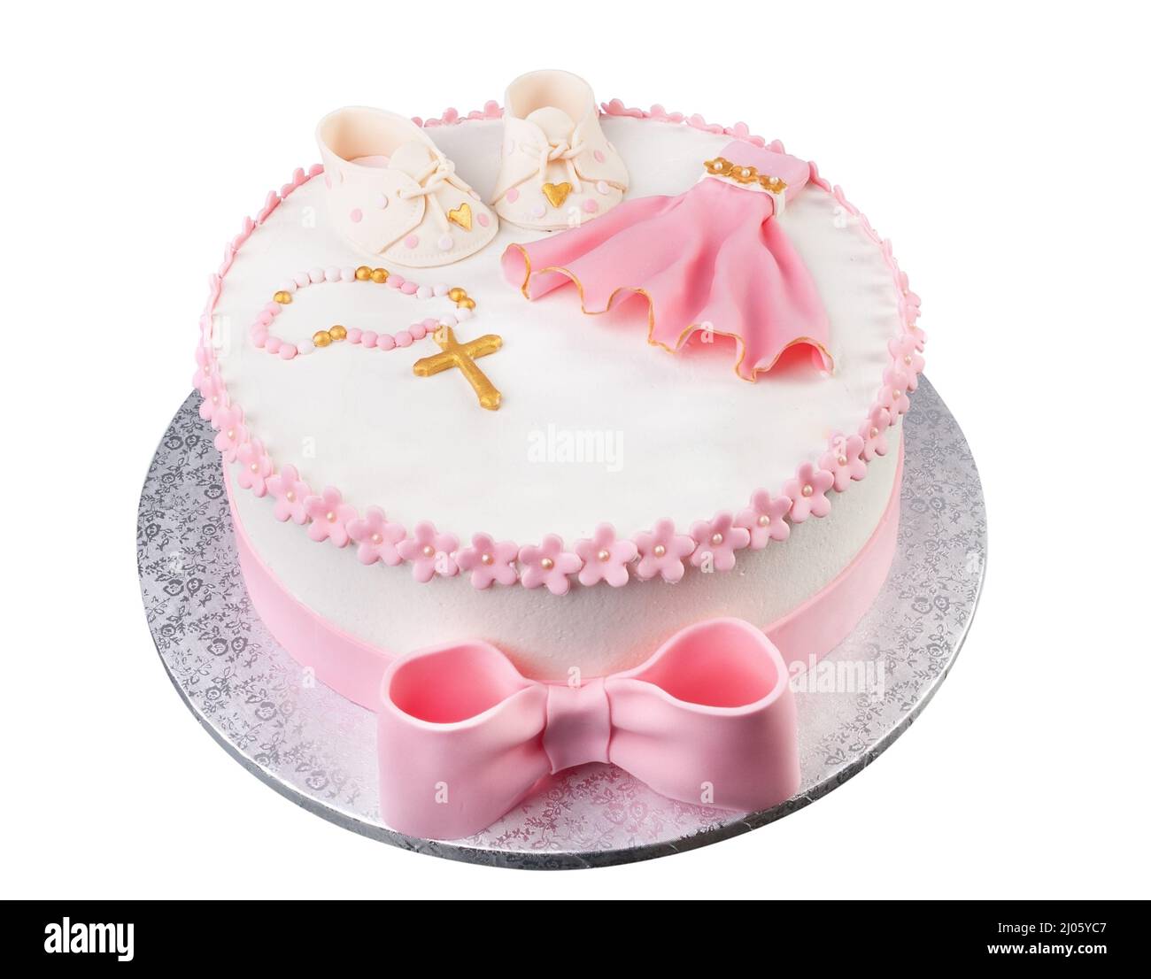 Un gâteau rose créatif avec une robe de croix et des bottes pour le baptême d'une jeune fille. Gros plan par le dessus. Banque D'Images