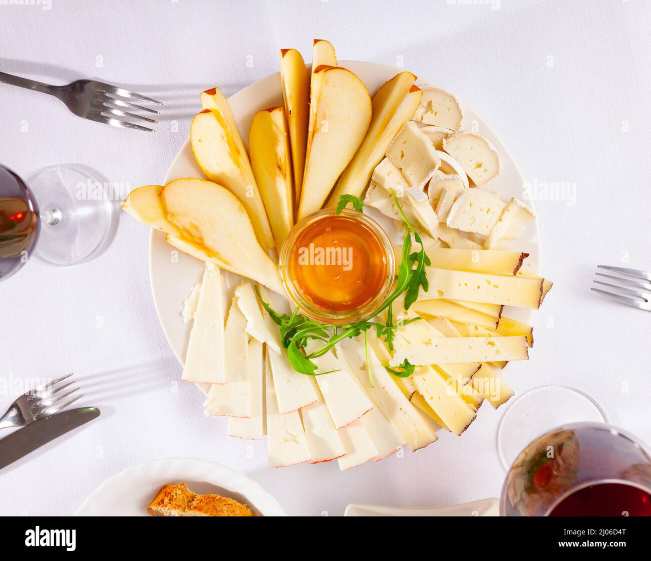 Assiette avec différents types de fromage et une tasse de miel Banque D'Images