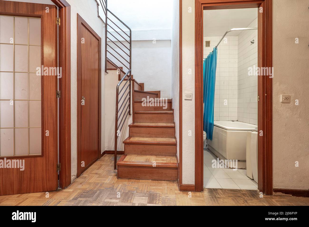 Distributeur d'une maison en duplex avec salle de bains, entrée d'un salon avec une porte en verre et escaliers au deuxième étage Banque D'Images