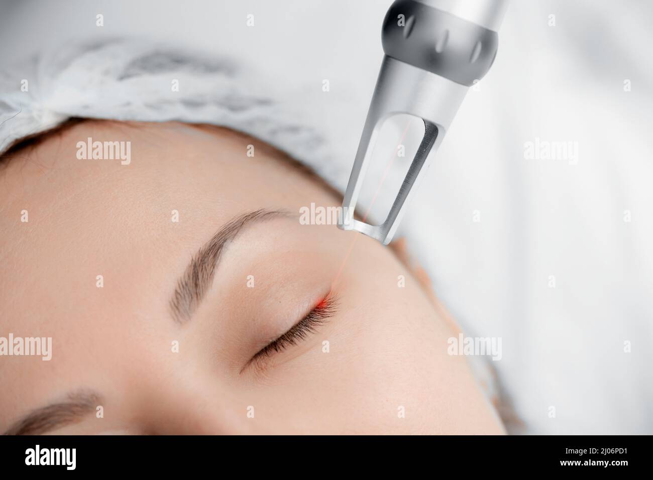 Enlèvement au laser de faux cils permanents de la jeune femme en salon. Concept rajeunissement procédure soins de la peau. Banque D'Images