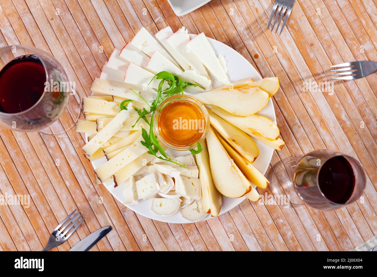 Assiette avec différents types de fromage et une tasse de miel Banque D'Images