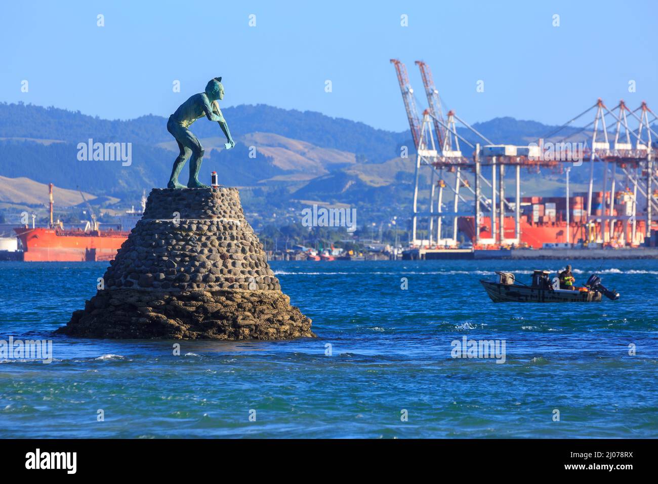 Une statue de Tangaroa, le dieu maori de la mer, dans le port de Tauranga, en Nouvelle-Zélande. En arrière-plan sont les grues du port de Tauranga Banque D'Images