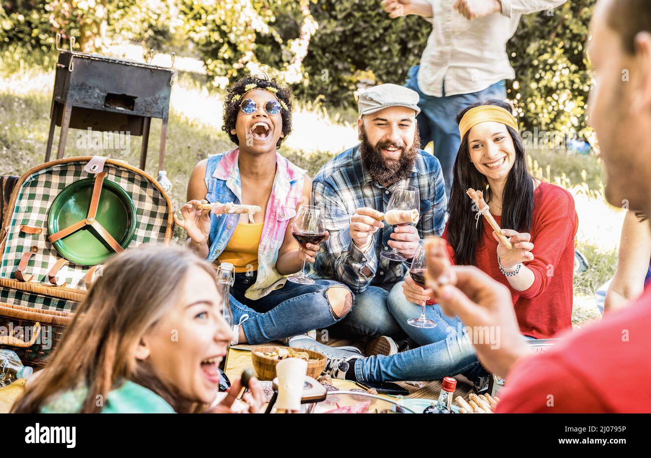 Groupe d'amis heureux qui se amusent en plein air au pique-nique au barbecue avec des collations nourriture boire du vin rouge - jeunes appréciant les vacances d'été ensemble à l'île de ba Banque D'Images