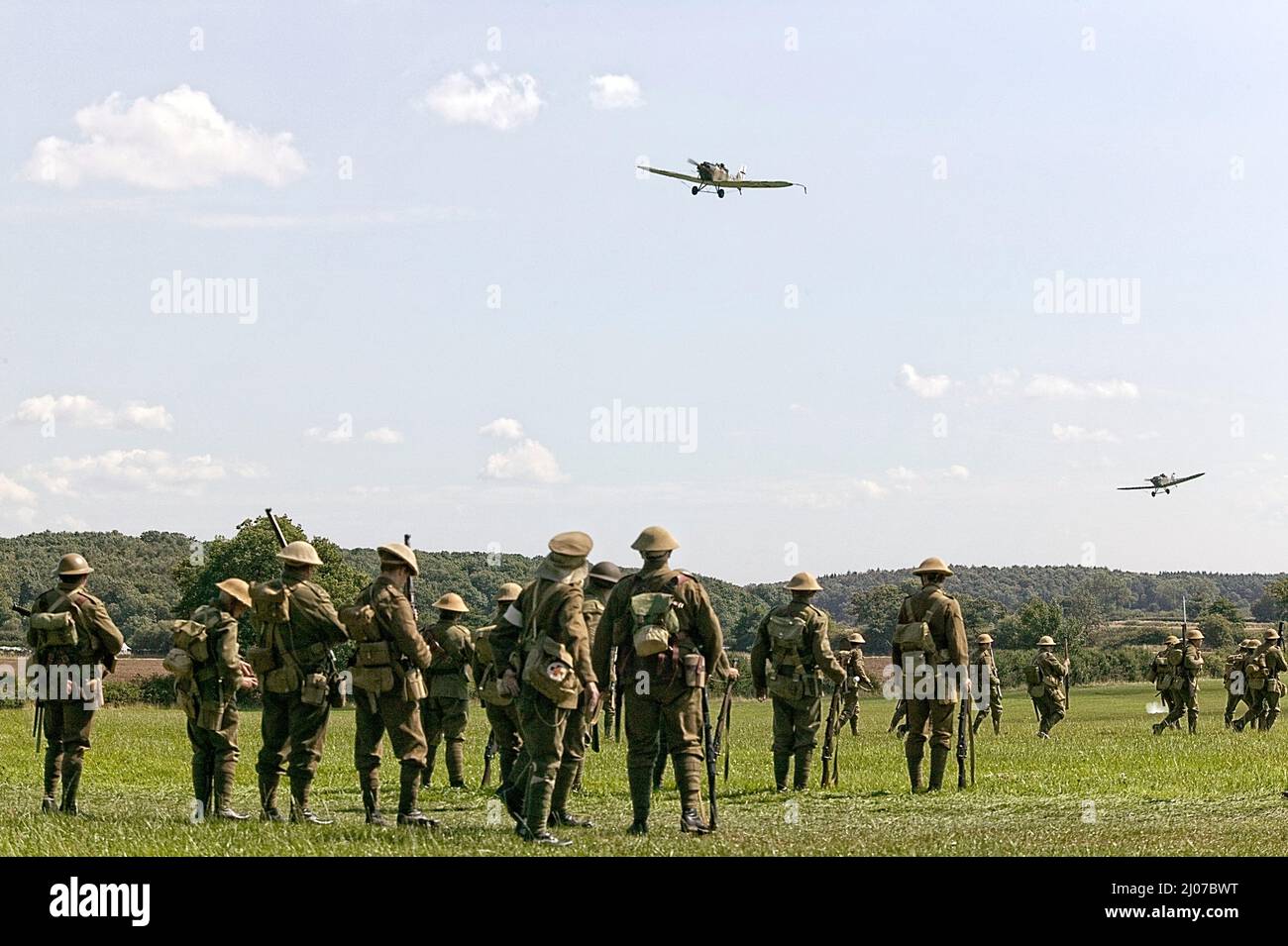 Reconstitution d'un groupe de troupes de la première Guerre mondiale de 1914-18 avec un avion d'époque au-dessus de la tête Banque D'Images