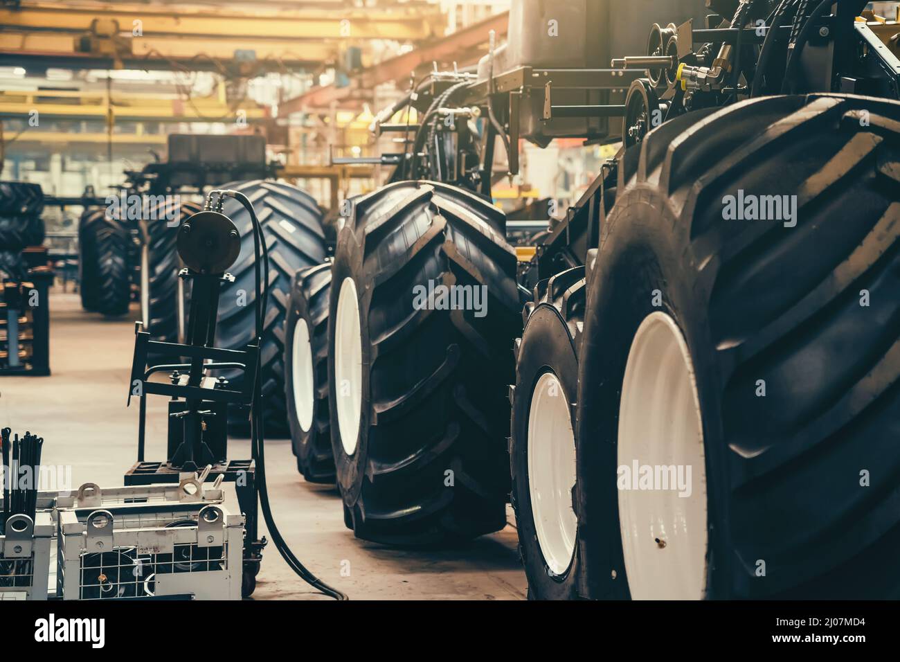 Ligne de convoyeur pour la production et l'assemblage de grandes machines industrielles, de tracteurs ou de moissonneuses-batteuses avec pneus en caoutchouc en usine. Banque D'Images
