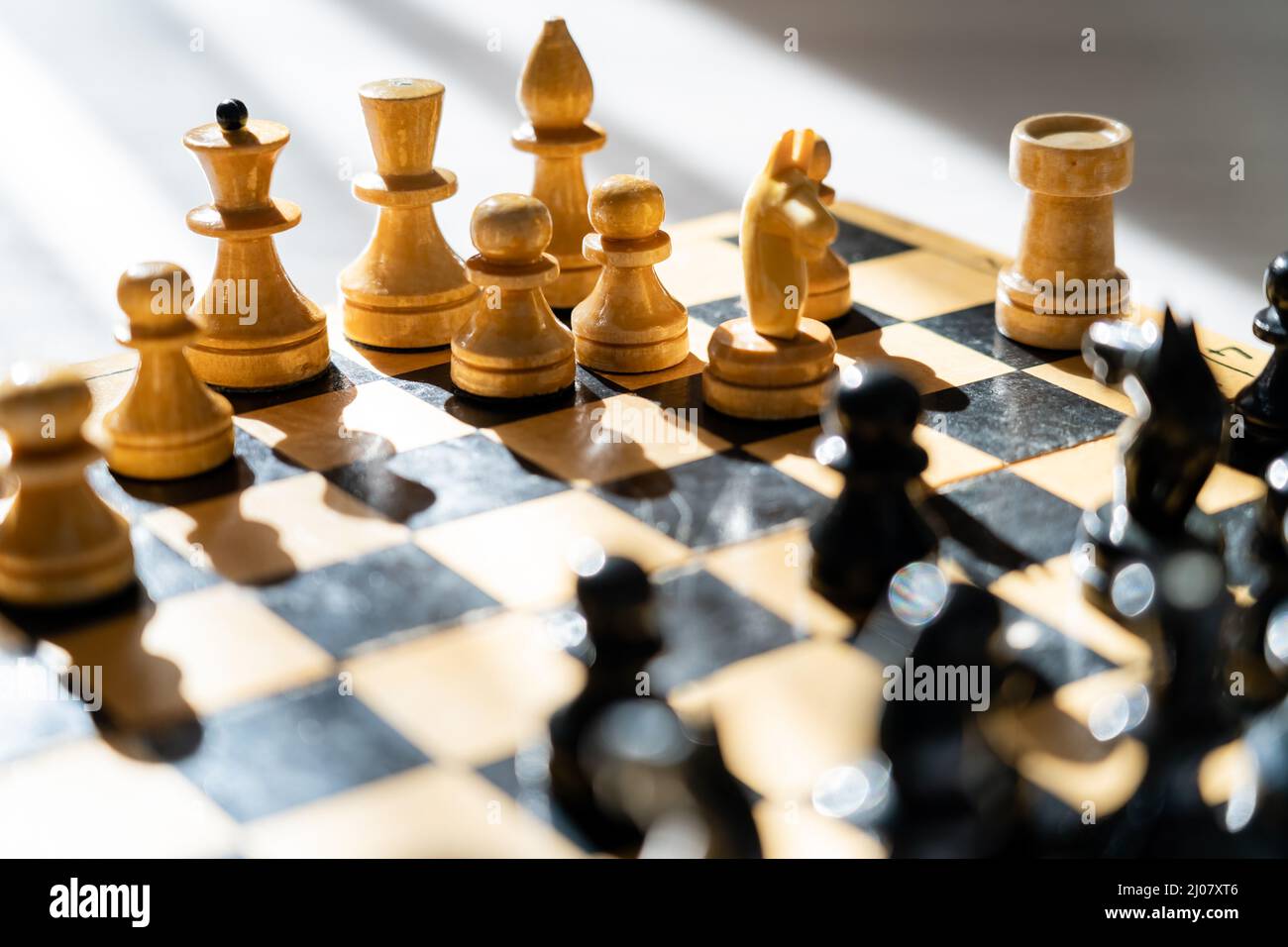 Personnages d'échecs en bois sur échiquier sur fond gris Banque D'Images