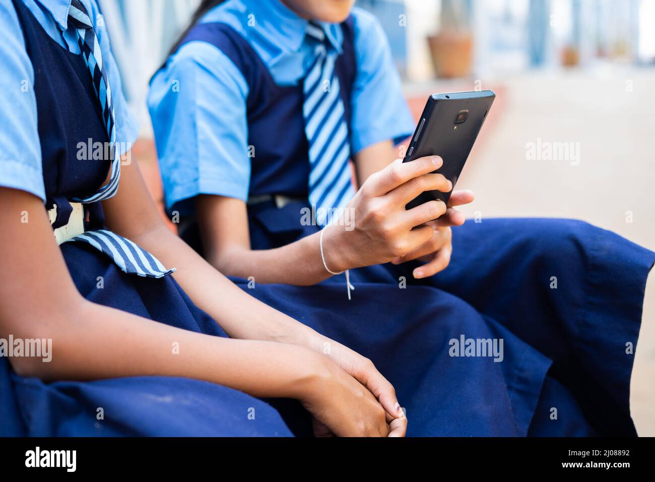 gros plan sur les mains des enfants à l'école en utilisant le téléphone mobile en cachant- concetant la dépendance au smartphone, en utilisant les médias sociaux et en palifiant des jeux. Banque D'Images