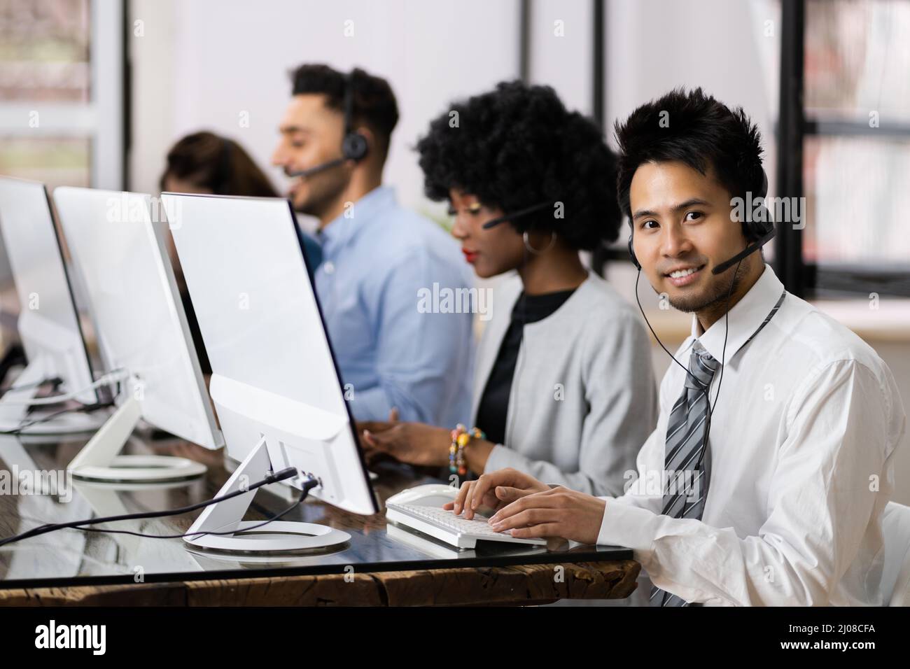 Agent de service client positif avec micro-casque travaillant dans Un centre d'appels Banque D'Images