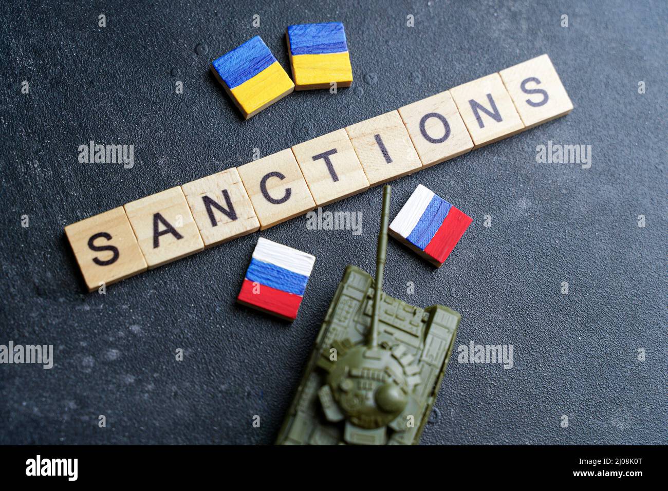 Concept de sanctions contre la Russie. Réservoir à jouets et inscription sanctions sur fond sombre. Conflit de guerre en Ukraine, défaut de paiement, crise économique et monétaire en Russie. Photo de haute qualité Banque D'Images