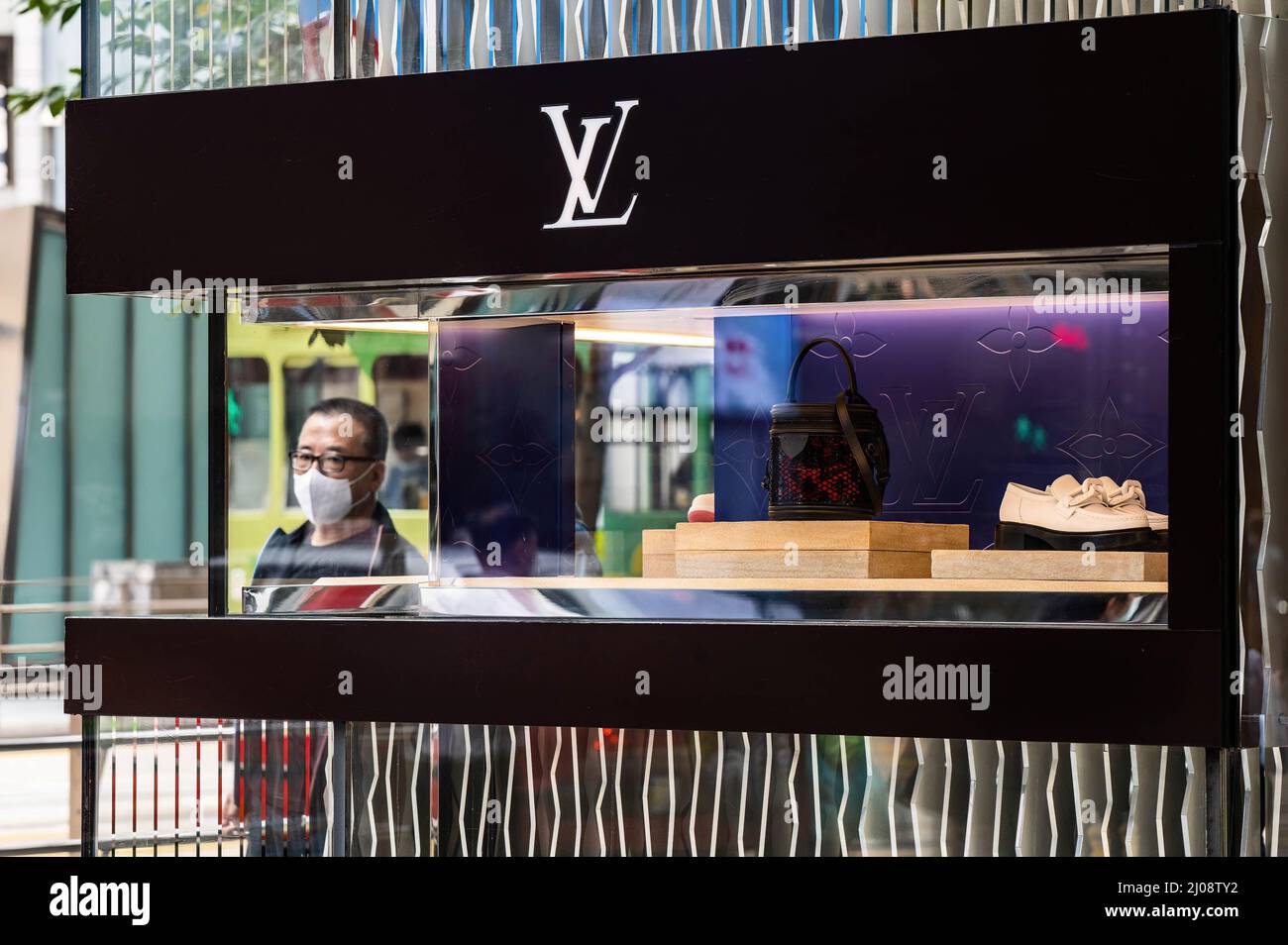 Hong Kong, Chine. 16th mars 2022. Un homme dans un masque chirurgical marche à côté d'un magasin Louis Vuitton dans le quartier central des affaires de Hong Kong. Selon l'analyse économique du Gouvernement de Hong Kong, le secteur du commerce de détail est confronté à une pression énorme à court terme, la pandémie et les mesures de distanciation sociale qui y sont associées créent des défis pour une renaissance. (Image de crédit : © Ben Marans/SOPA Images via ZUMA Press Wire) Banque D'Images