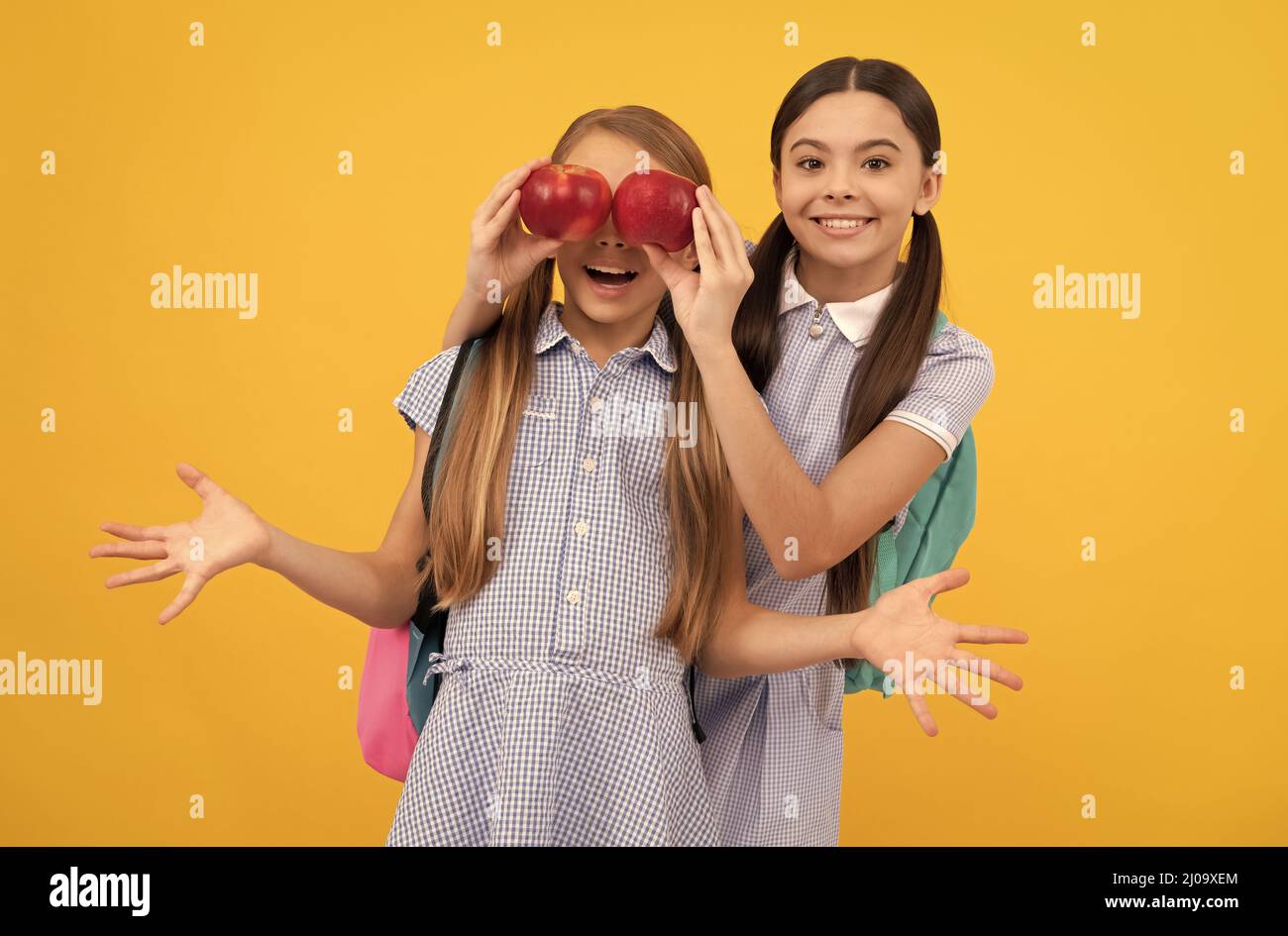 Enfant heureux couverture classmate yeux avec pommes fond jaune, santé des yeux Banque D'Images