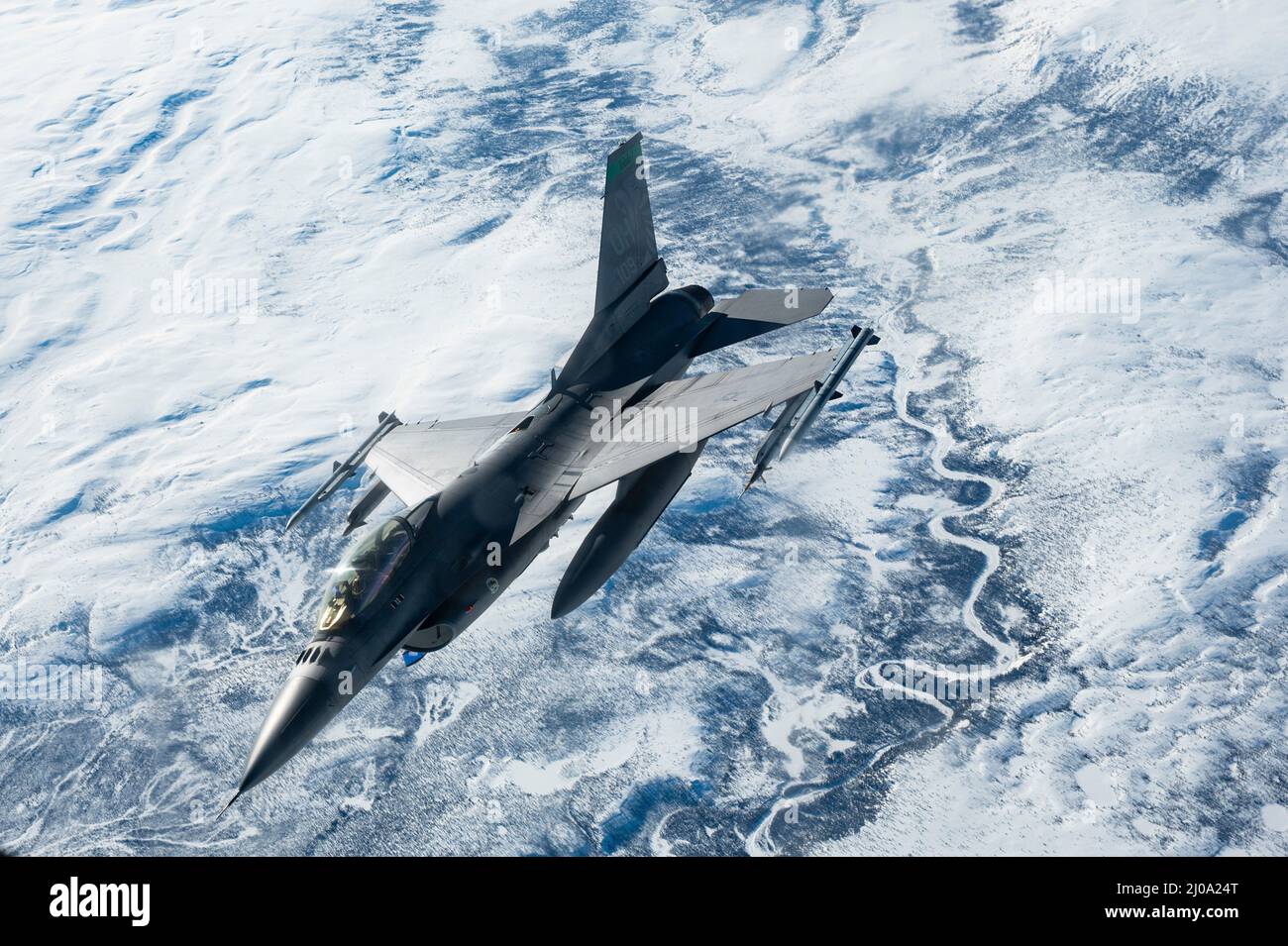 Un faucon de combat F-16 de la Force aérienne des États-Unis, affecté à la 180th Fighter Wing, survole l'Alaska pendant l'exercice du Commandement du Nord des États-Unis ARCTIC EDGE 2022, le 15 mars 2022. AE22 est un exercice biennal de défense de la patrie conçu pour fournir une formation conjointe de haute qualité et efficace dans des conditions austères par temps froid. (É.-U. Photo de la Force aérienne par le sergent d'état-major. Taylor Crul) Banque D'Images