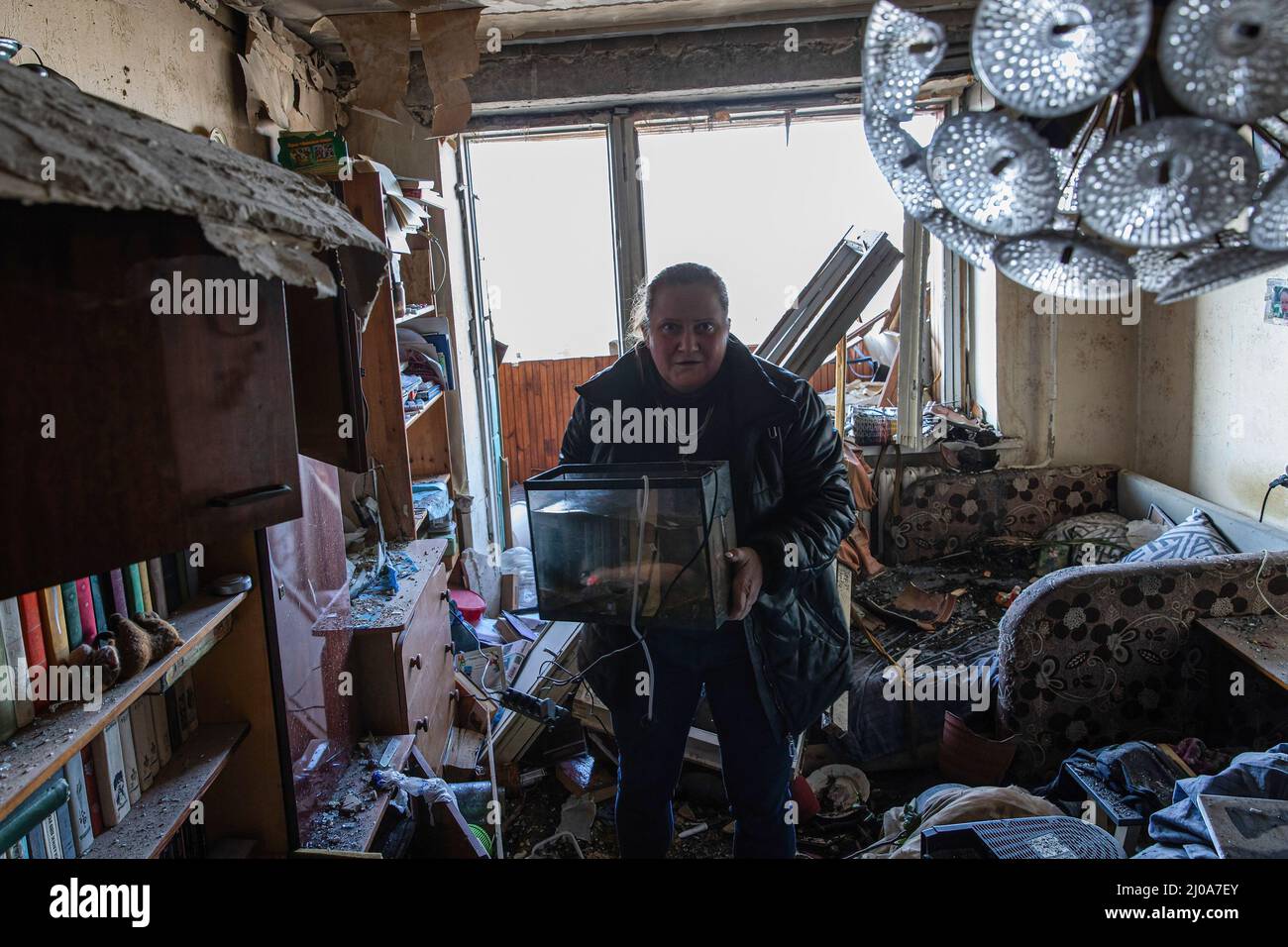 Kiev, Ukraine. 17th mars 2022. Une femme a vu récupérer ses trucs de son appartement endommagé. Alors que la Russie intensifie les bombardements offensifs et les frappes aériennes tout en encerclant la capitale ukrainienne, un bâtiment résidentiel a été frappé par des bombardements mercredi matin, le 16 mars 2022, tuant au moins un civil et en blessant des dizaines de personnes. Crédit : SOPA Images Limited/Alamy Live News Banque D'Images