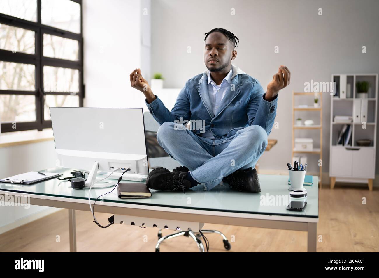 Un employé africain faisant de la santé mentale Yoga Méditation en bureau Banque D'Images