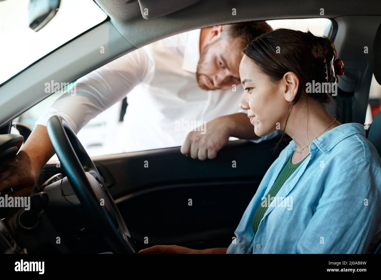 Ce bouton permet de démarrer la voiture. Photo d'un homme d'affaires offrant à un client une visite de sa nouvelle voiture. Banque D'Images