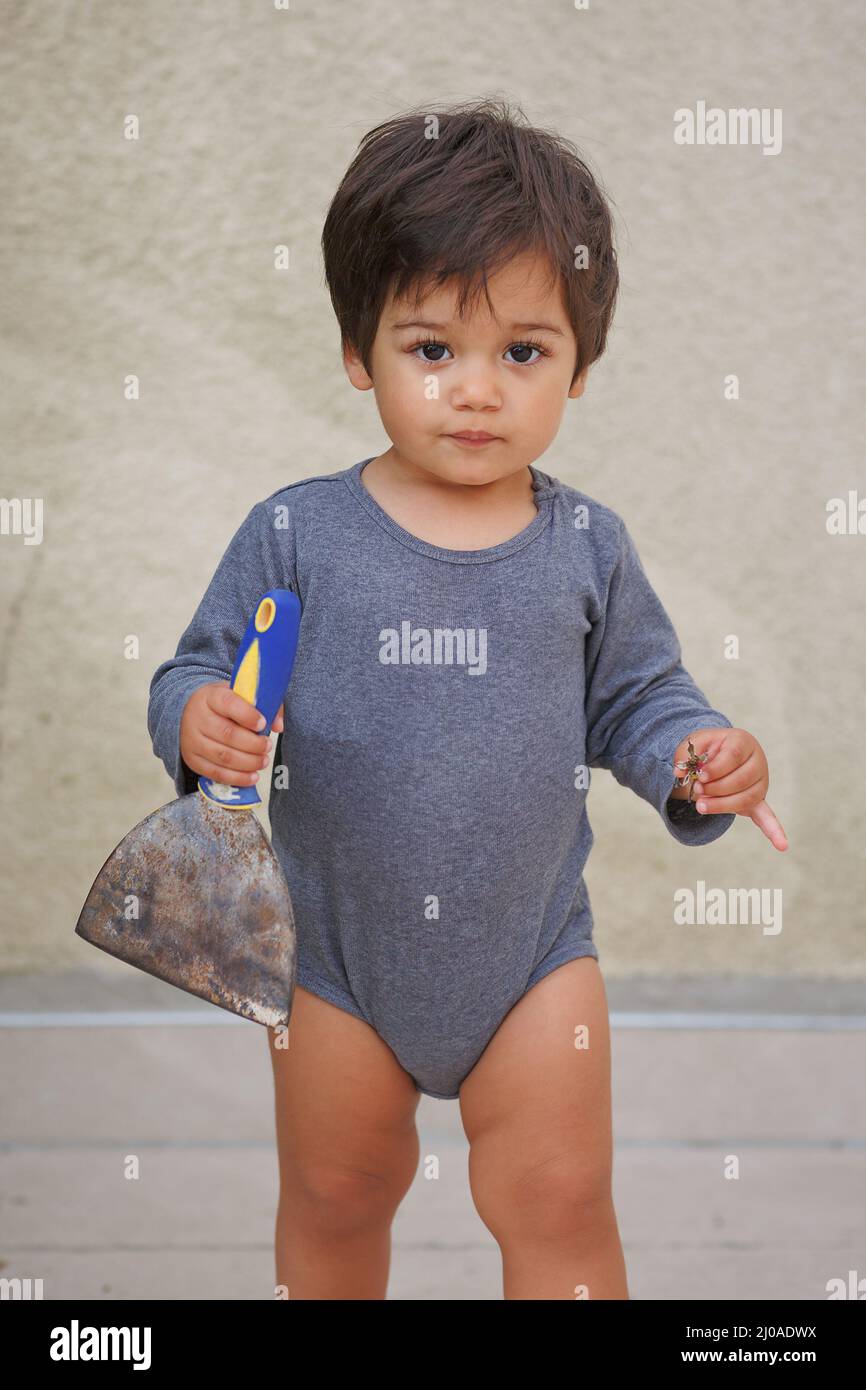 Portrait d'un petit garçon de l'est jouant à l'extérieur avec la spatule à  outils. Jeu d'enfant arabe avec couteau à mastiquer. Travaux de  construction à la maison. CHIL Photo Stock - Alamy