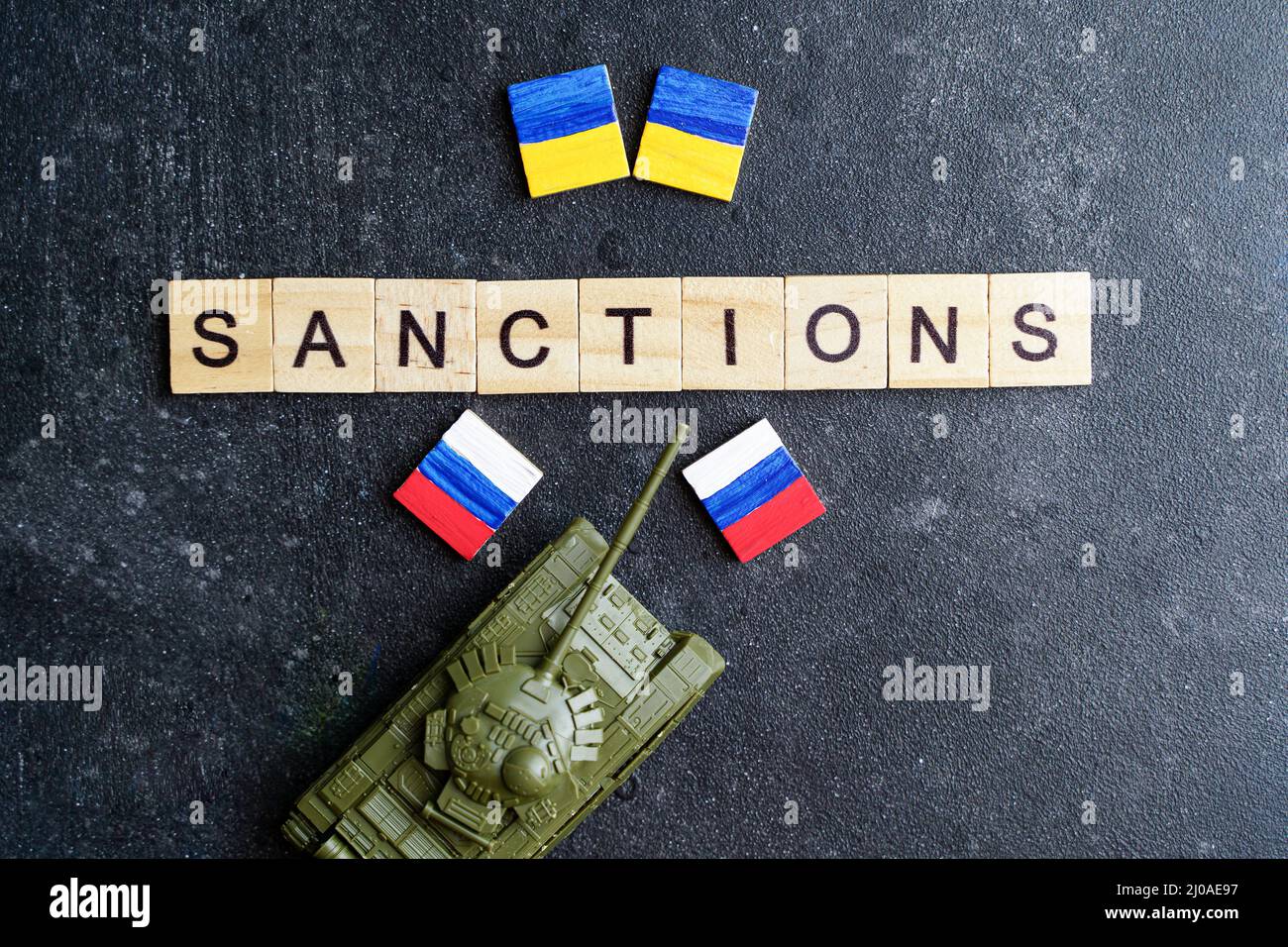Concept de sanctions contre la Russie. Réservoir à jouets et inscription sanctions sur fond sombre. Conflit de guerre en Ukraine, défaut de paiement, crise économique et monétaire en Russie. Photo de haute qualité Banque D'Images