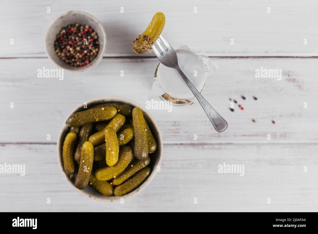 Conserver les concombres marinés, les assaisonnements et l'ail sur une table en bois blanc. Aliments fermentés sains. Légumes en conserve à la maison. Banque D'Images