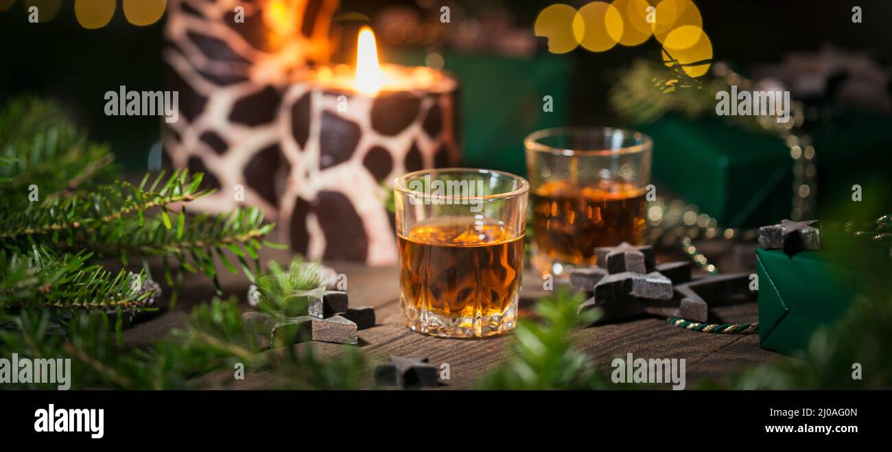 Deux verres de whisky ou bourbon avec décoration de vacances sur fond de bois. Le concept d'ambiance Whiskey pour les fêtes de nouvel an, de Noël et d'hiver Banque D'Images