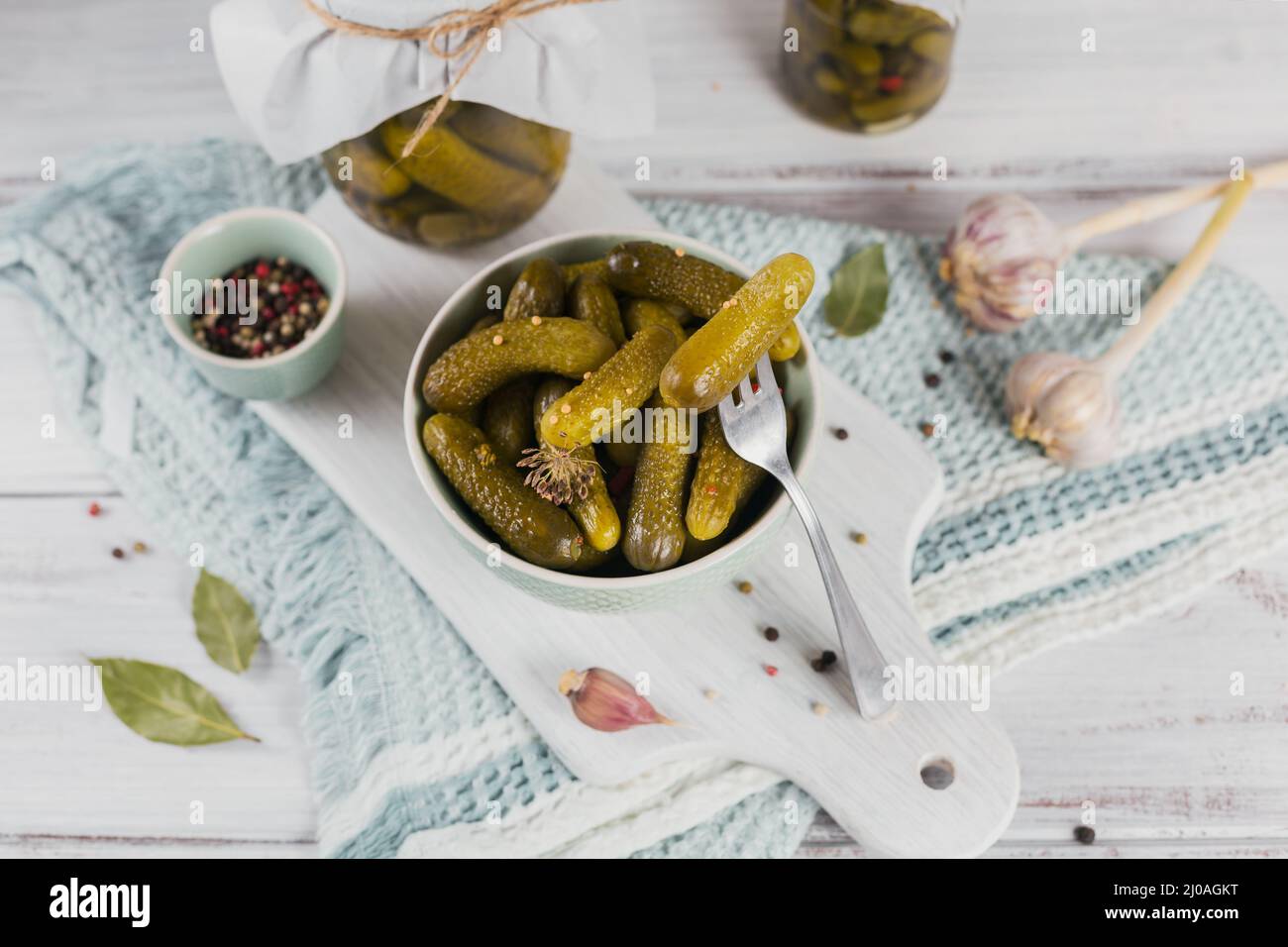 Conserver les concombres marinés, les assaisonnements et l'ail sur une table en bois blanc. Aliments fermentés sains. Légumes en conserve à la maison. Banque D'Images
