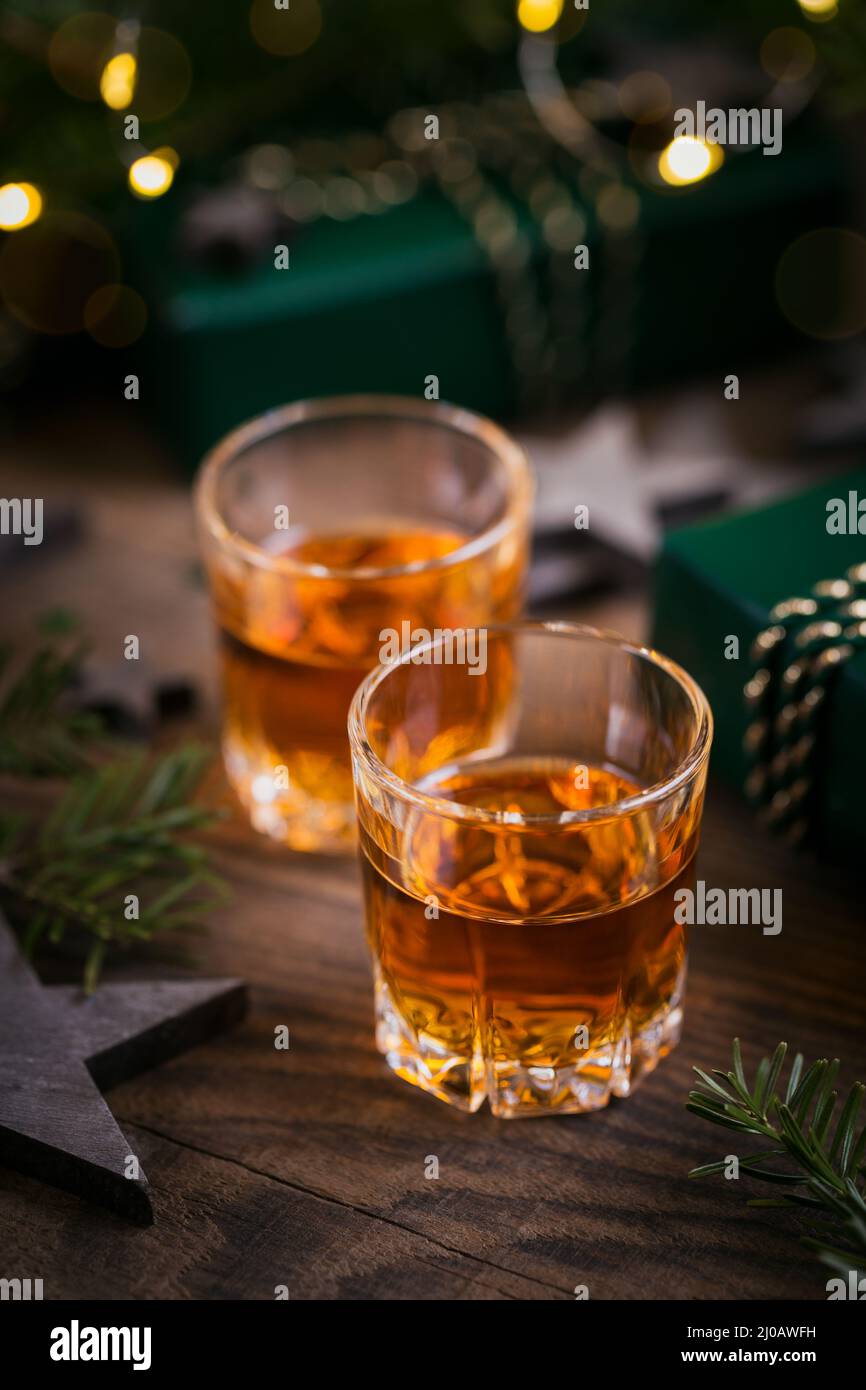 Deux verres de whisky ou bourbon avec décoration de vacances sur fond de bois. Le concept d'ambiance Whiskey pour les fêtes de nouvel an, de Noël et d'hiver Banque D'Images