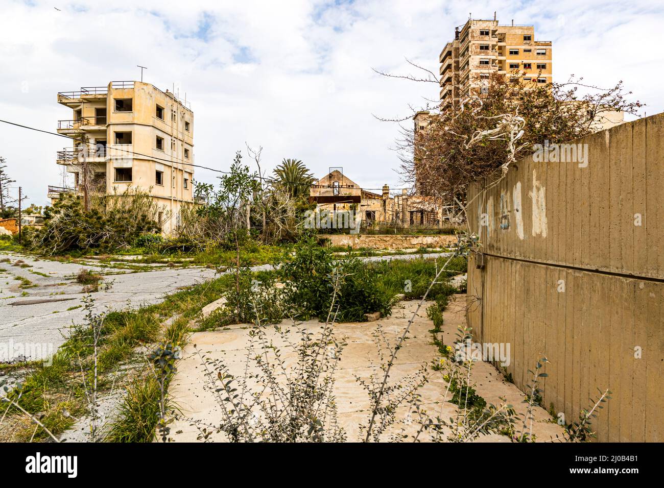 Le quartier de Varosha (Kapalı Maraş) à Famagouste (Chypre) était entre 1970 et 1974 l'une des destinations touristiques les plus populaires dans le monde. Ses habitants chypriotes grecs ont fui lors de l'invasion turque de Chypre en 1974, lorsque la ville de Famagouste est passée sous contrôle turc. Il est resté abandonné depuis et les bâtiments se sont dégradés. La plupart des habitants d'origine de Varosha (et leurs descendants directs) vivent maintenant au sud de la zone tampon des Nations Unies à Chypre. Ces familles sont toujours les propriétaires légaux des propriétés à Varosha, mais tant que la ville est combattue, elles ne peuvent pas la récupérer. En plus, beaucoup Banque D'Images