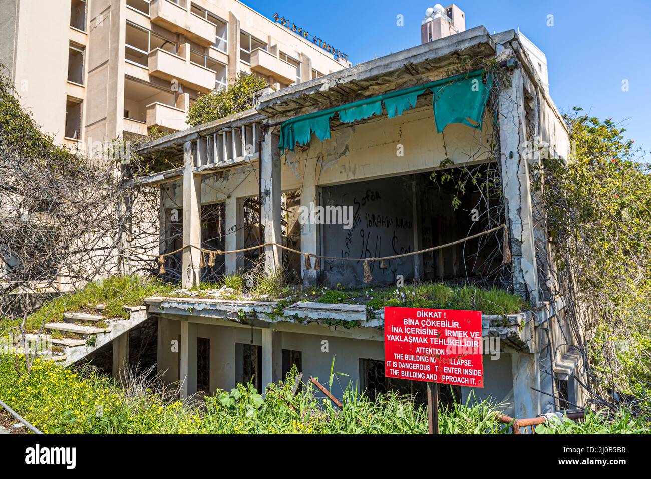 Le quartier de Varosha (Kapalı Maraş) à Famagouste (Chypre) était entre 1970 et 1974 l'une des destinations touristiques les plus populaires dans le monde. Ses habitants chypriotes grecs ont fui lors de l'invasion turque de Chypre en 1974, lorsque la ville de Famagouste est passée sous contrôle turc. Il est resté abandonné depuis et les bâtiments se sont dégradés. La plupart des habitants d'origine de Varosha (et leurs descendants directs) vivent maintenant au sud de la zone tampon des Nations Unies à Chypre. Ces familles sont toujours les propriétaires légaux des propriétés à Varosha, mais tant que la ville est combattue, elles ne peuvent pas la récupérer. En plus, beaucoup Banque D'Images