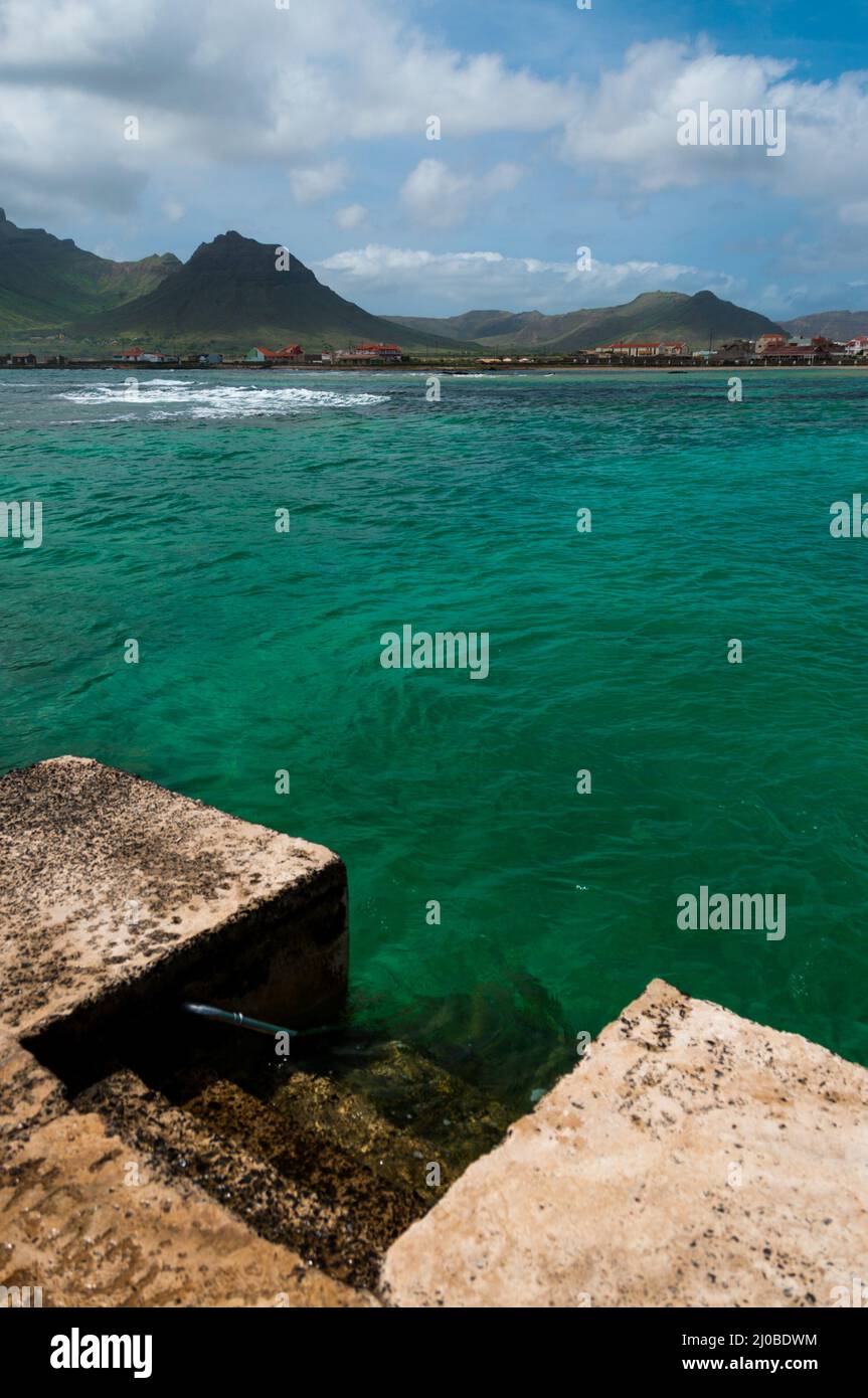 Escaliers en béton menant à l'eau de l'océan en face de la côte et de la montagne Banque D'Images