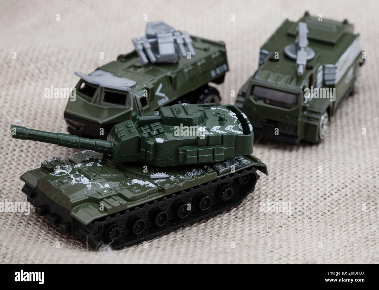 ours en peluche de style rustique sur un tissu hessien et rugueux avec des jouets de guerre, illustrant une enfance pendant une période de guerre Banque D'Images