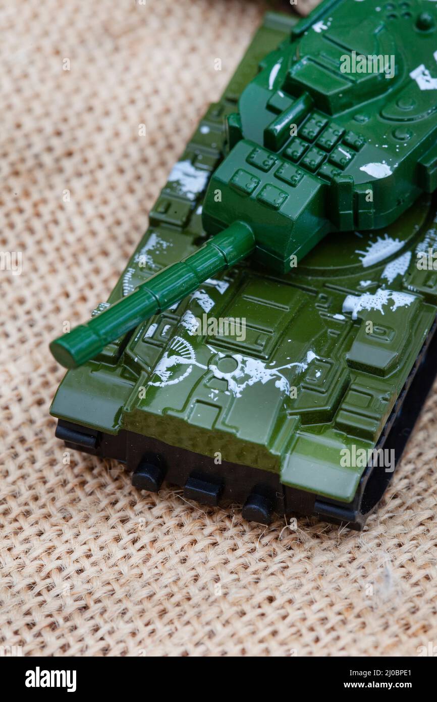 ours en peluche de style rustique sur un tissu hessien et rugueux avec des jouets de guerre, illustrant une enfance pendant une période de guerre Banque D'Images