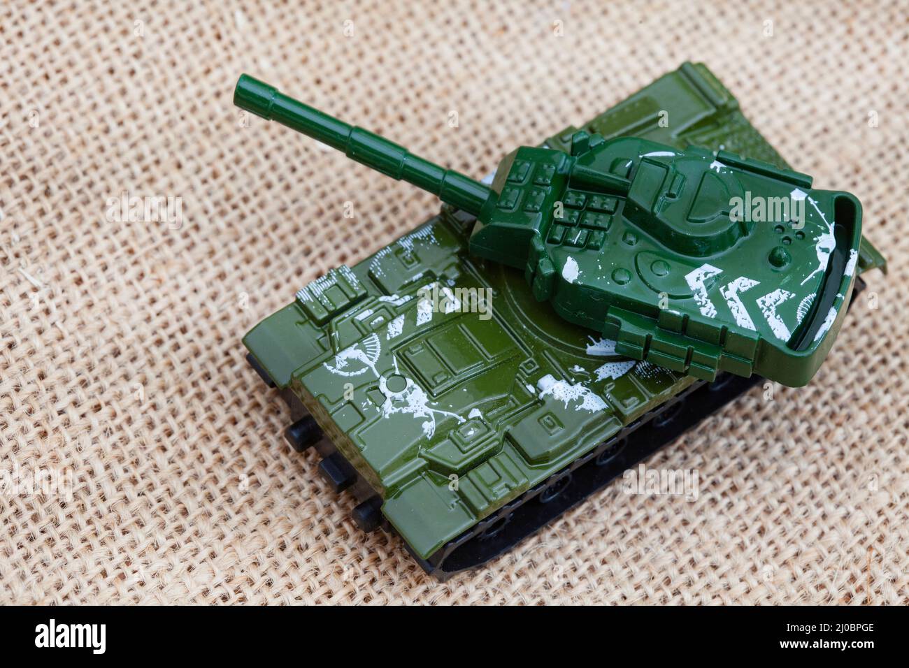 ours en peluche de style rustique sur un tissu hessien et rugueux avec des jouets de guerre, illustrant une enfance pendant une période de guerre Banque D'Images