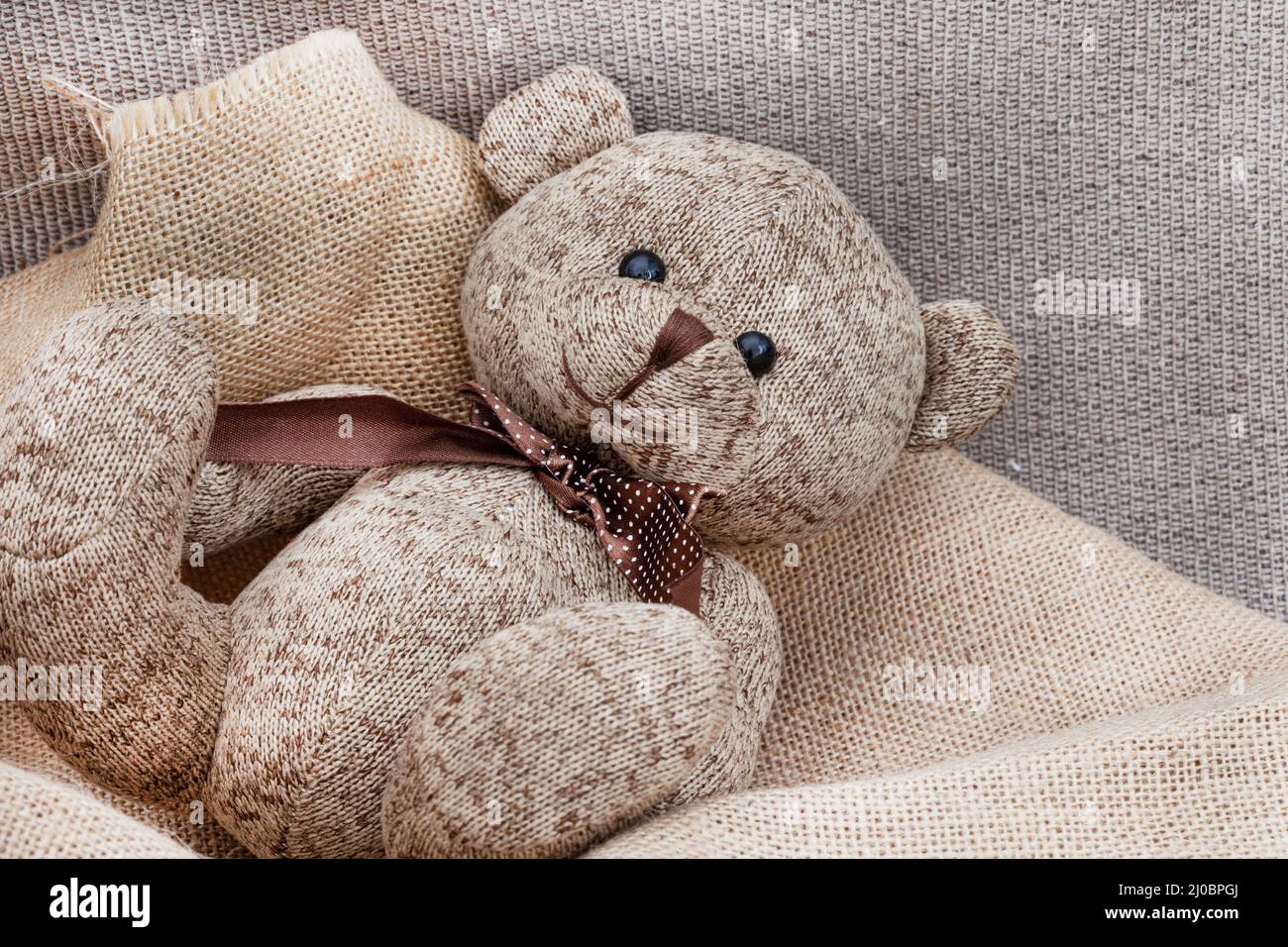 ours en peluche de style rustique sur un tissu de style hessien et rugueux Banque D'Images