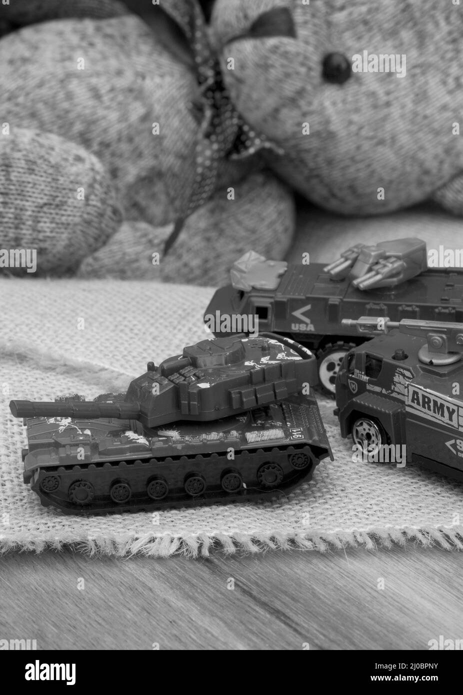 ours en peluche de style rustique sur un tissu hessien et rugueux avec des jouets de guerre, illustrant une enfance pendant une période de guerre Banque D'Images