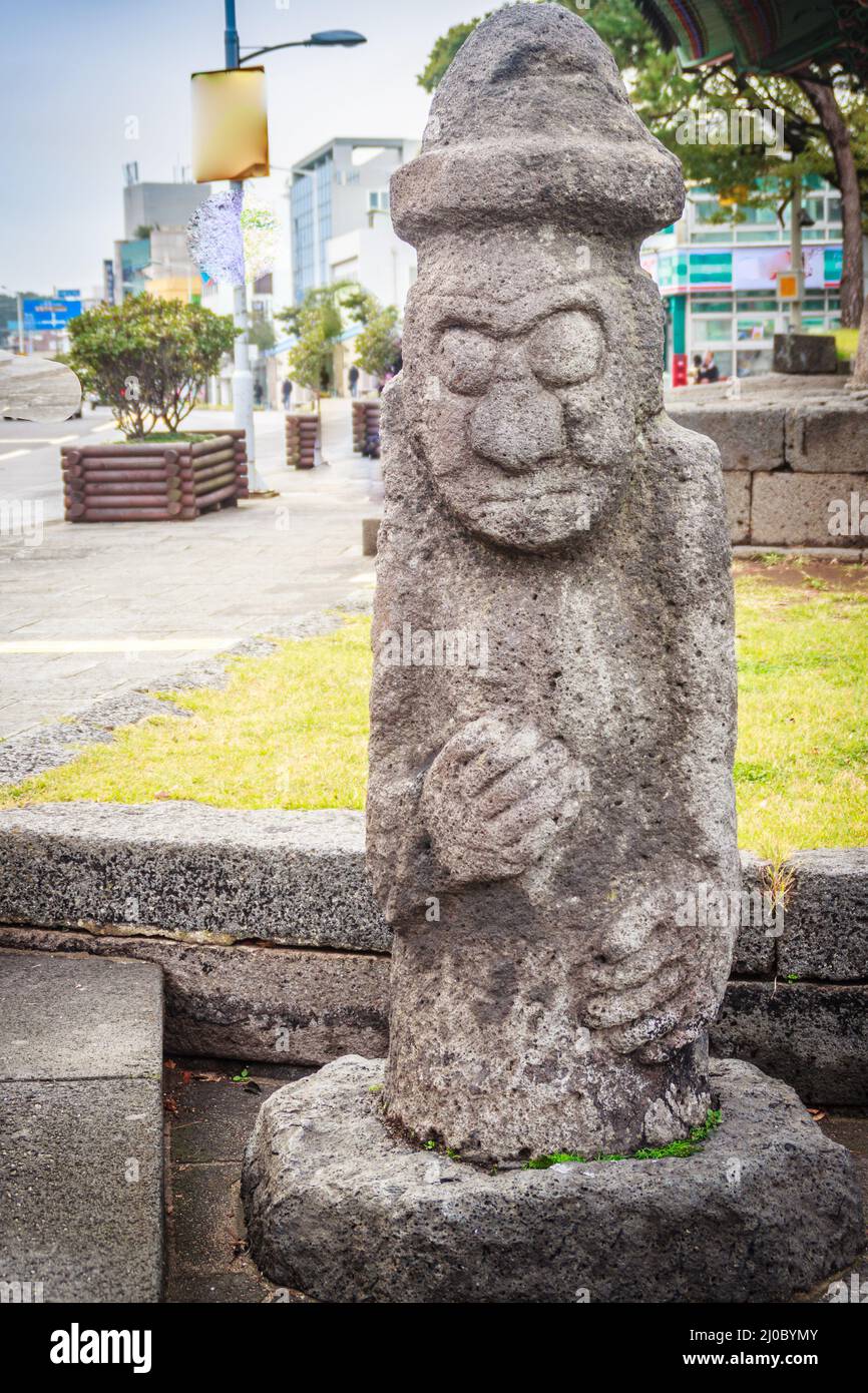 L'idole de pierre (Dolharubang, les pierres du grand-père) devant Jeju Mokgwana, le plus ancien bâtiment restant à Jeju pour l'ancien cen Banque D'Images