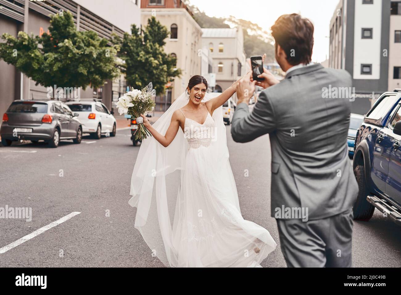 Faire de leur grand jour un jour mémorable. Photo d'un marié prenant une photo de sa mariée sur son téléphone portable. Banque D'Images