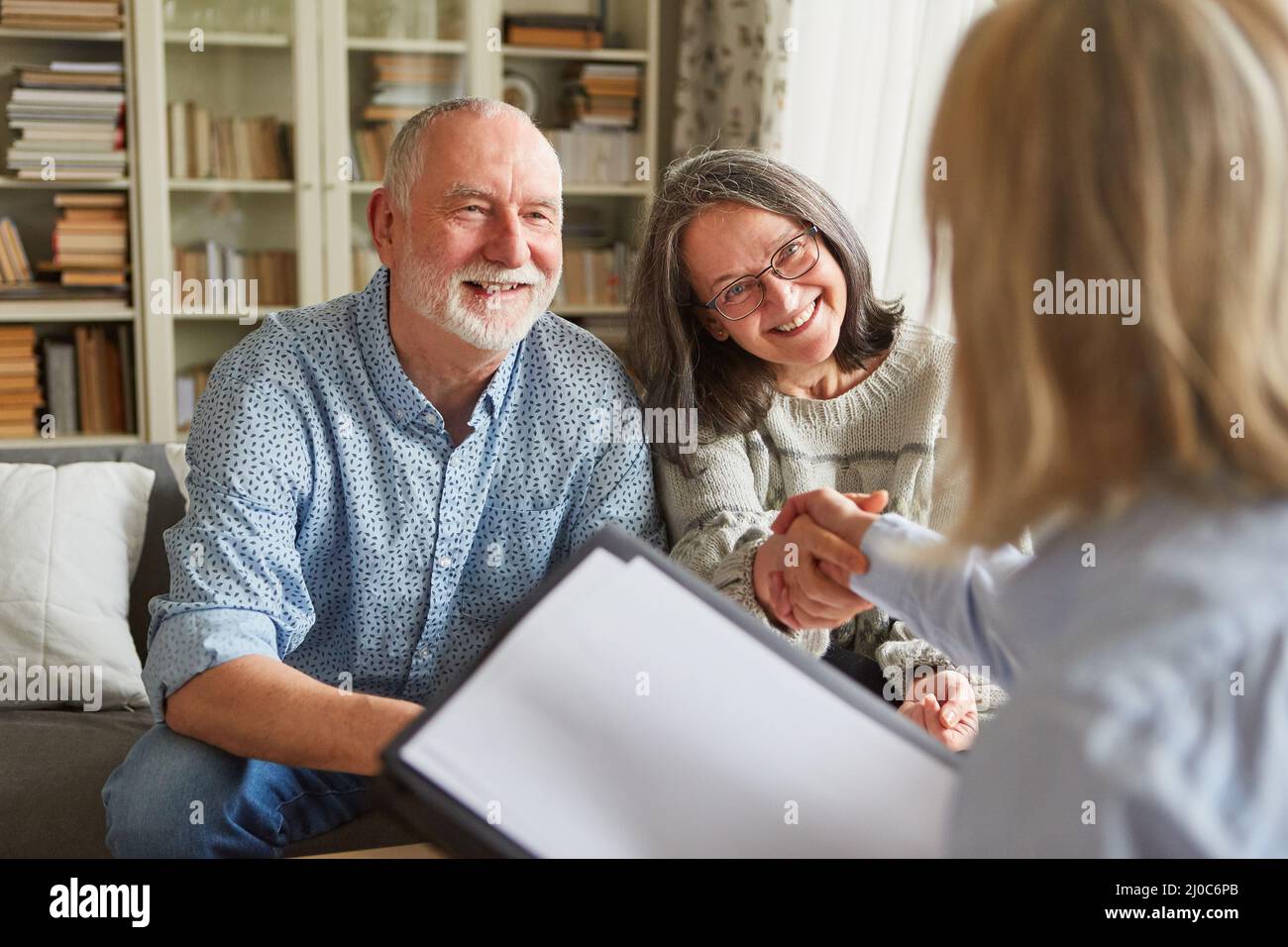 Un conseiller en retraite et un couple de personnes âgées se sont mis à la main après une consultation sur les soins et la planification de la retraite Banque D'Images