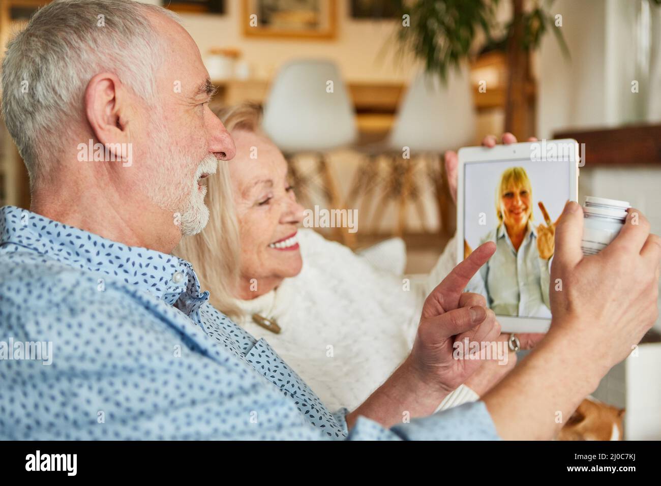 Le médecin conseille un couple de personnes âgées malades sur la tablette électronique en ligne pendant une consultation vidéo Banque D'Images