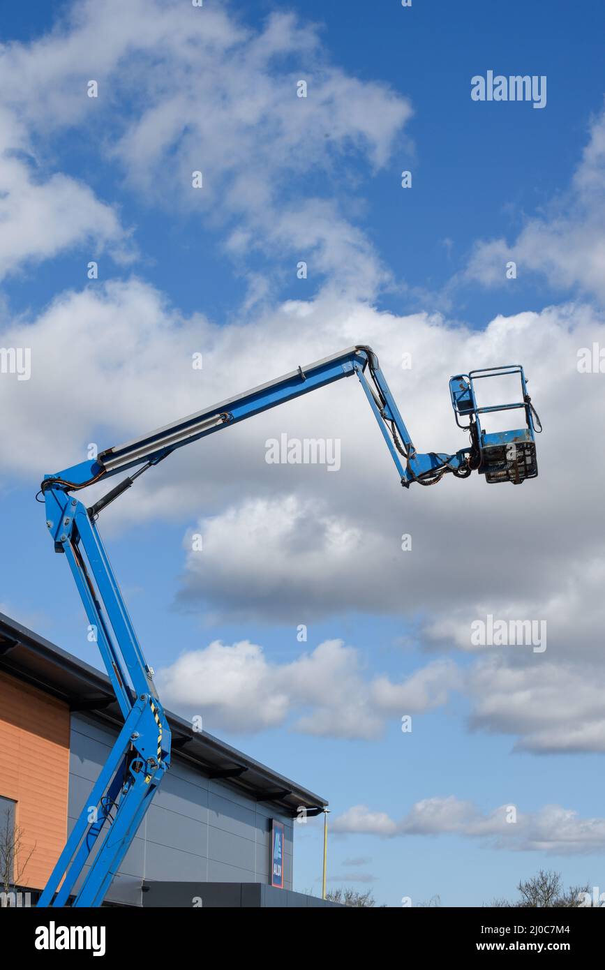 Plate-forme de levage de cueilleur de cerisier avec bras télescopique sur un chantier de construction pour atteindre les plus hauts niveaux dans l'industrie de la construction Banque D'Images