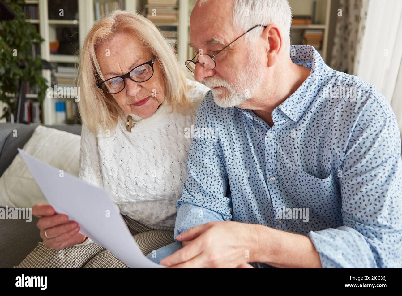 Couple d'aînés lisant un contrat ou un mandataire de soins de santé ou un volonté de vivre Banque D'Images