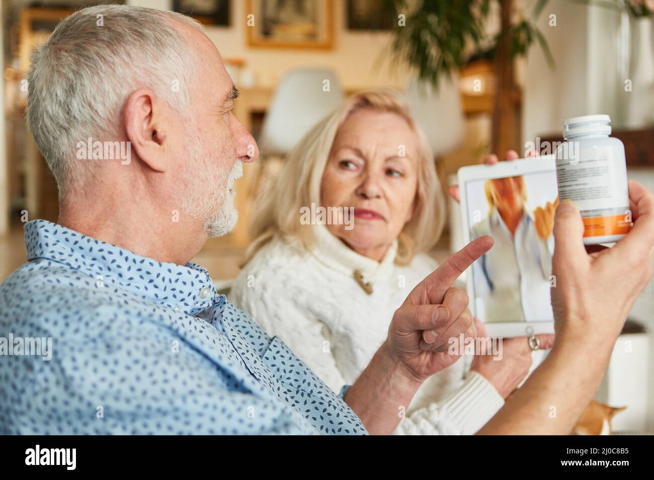 Les aînés parlent au médecin au sujet des médicaments dans la consultation vidéo sur l'ordinateur tablette Banque D'Images