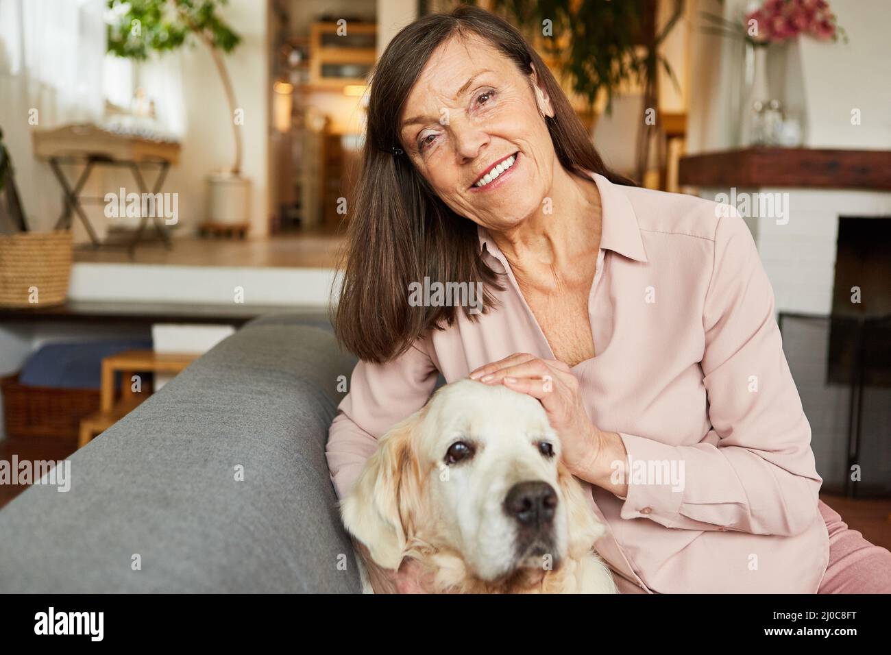 Bonne femme âgée en tant que pensionné avec son chien de retriever pour l'amitié et la compagnie Banque D'Images