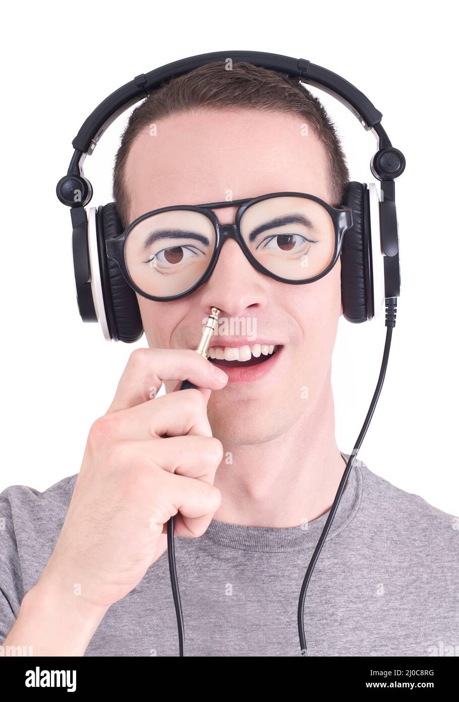 Drôle de DJ - Jeune homme avec des écouteurs et des lunettes de soleil stupides Banque D'Images