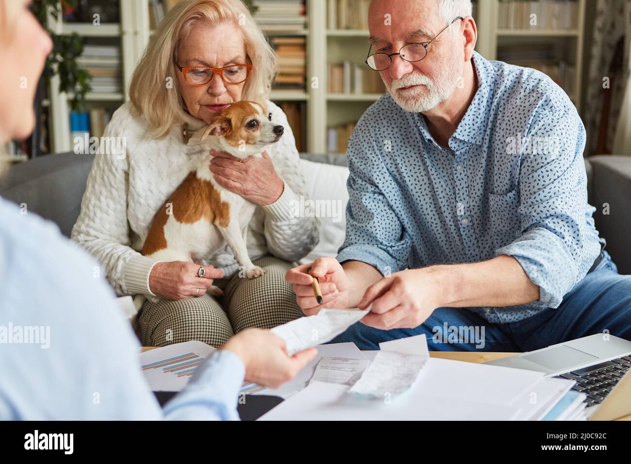 Un couple senior avec des reçus aide à préparer des déclarations de revenus à la maison Banque D'Images