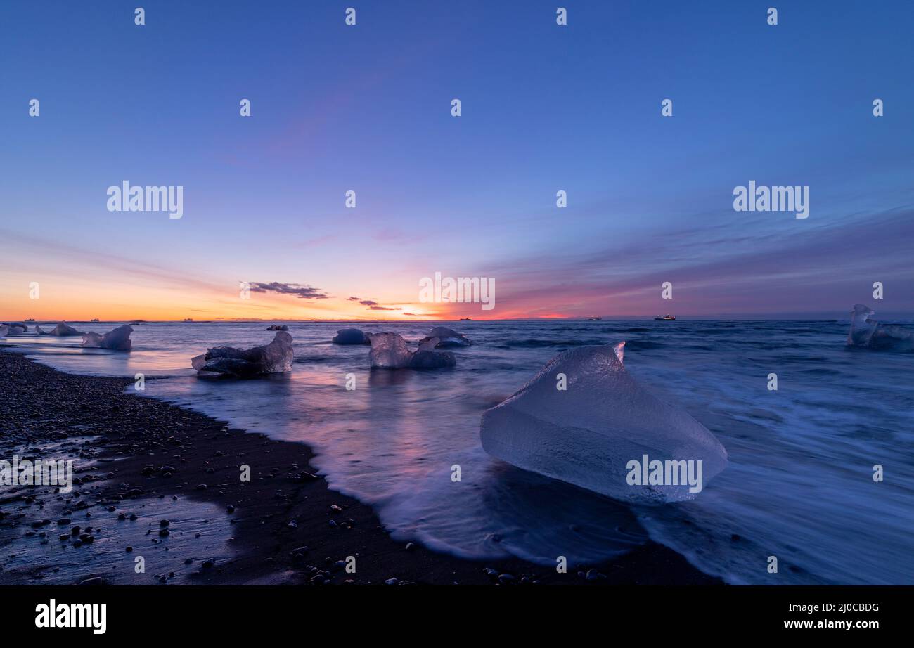 Lever du soleil et icebergs à Diamond Beach, Breidamerkursandur, sud-est de l'Islande Banque D'Images