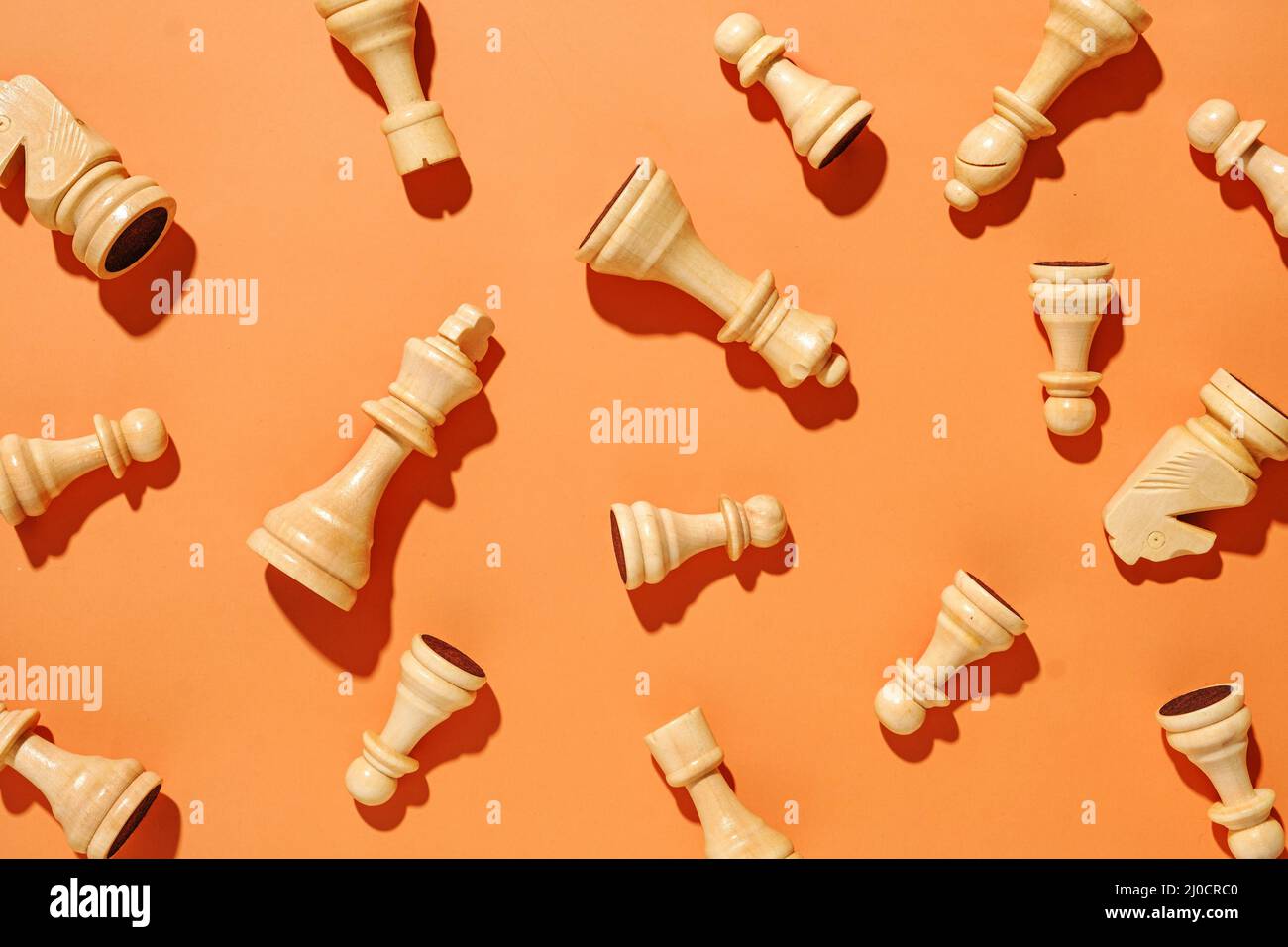 Motif de pièces d'échecs blanches sur fond orange. Concept minimal de conflit et de victoire dans la vie ou les affaires sportives. Banque D'Images
