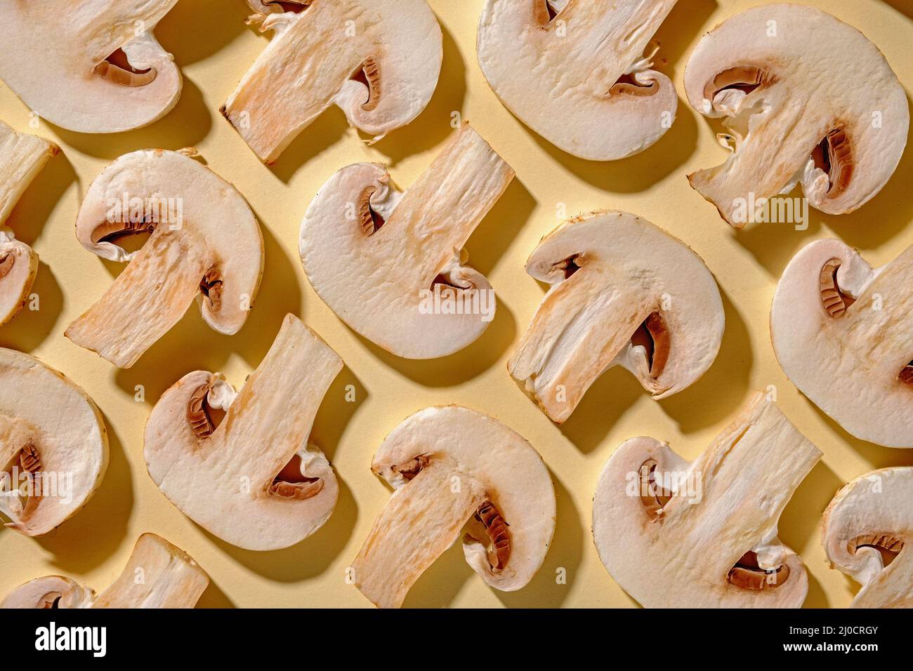 Motif de champignons frais sur fond jaune pour la cuisson. Concept moderne minimaliste et couleur pastel. Banque D'Images